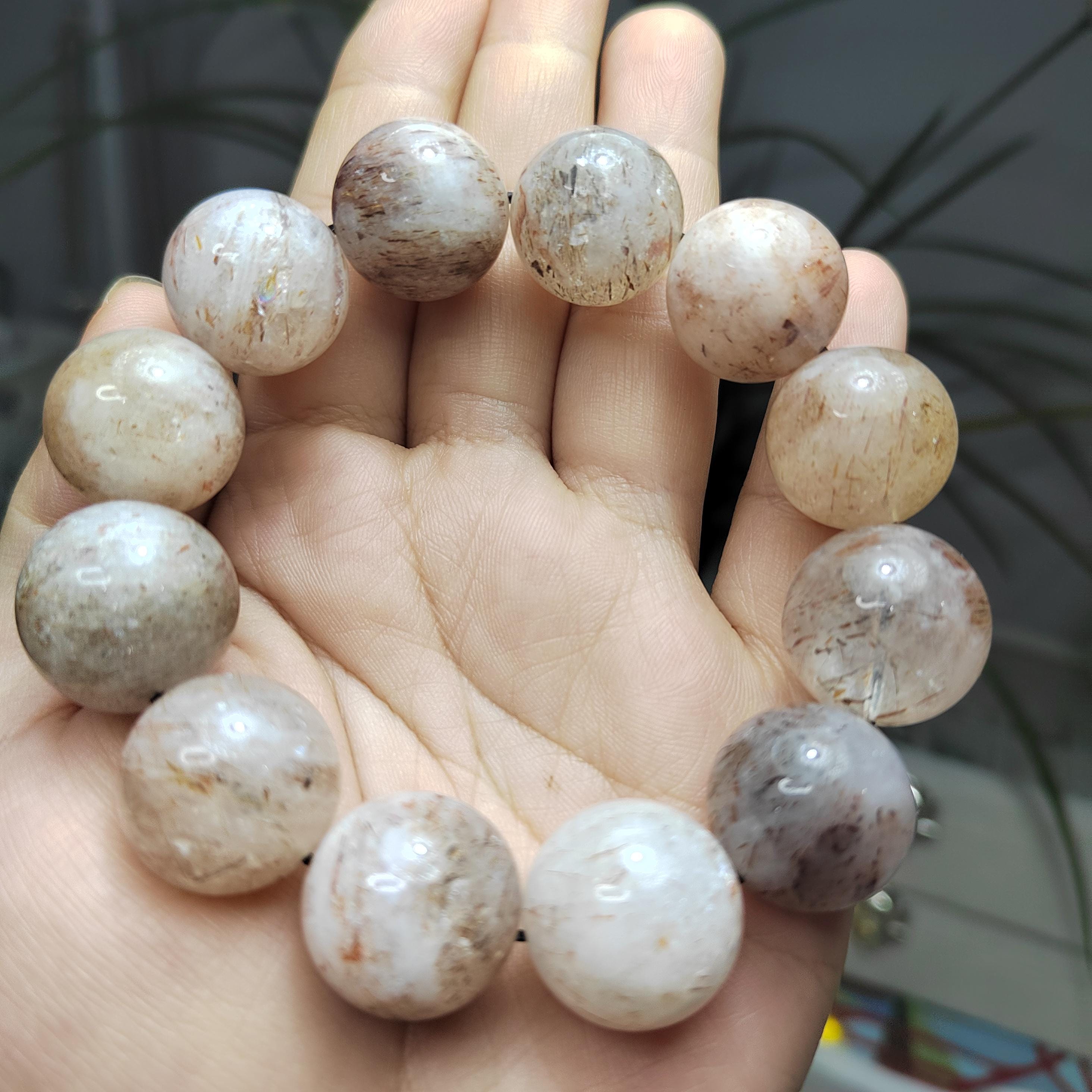 Hand holding a stack of round, beige-colored stones.