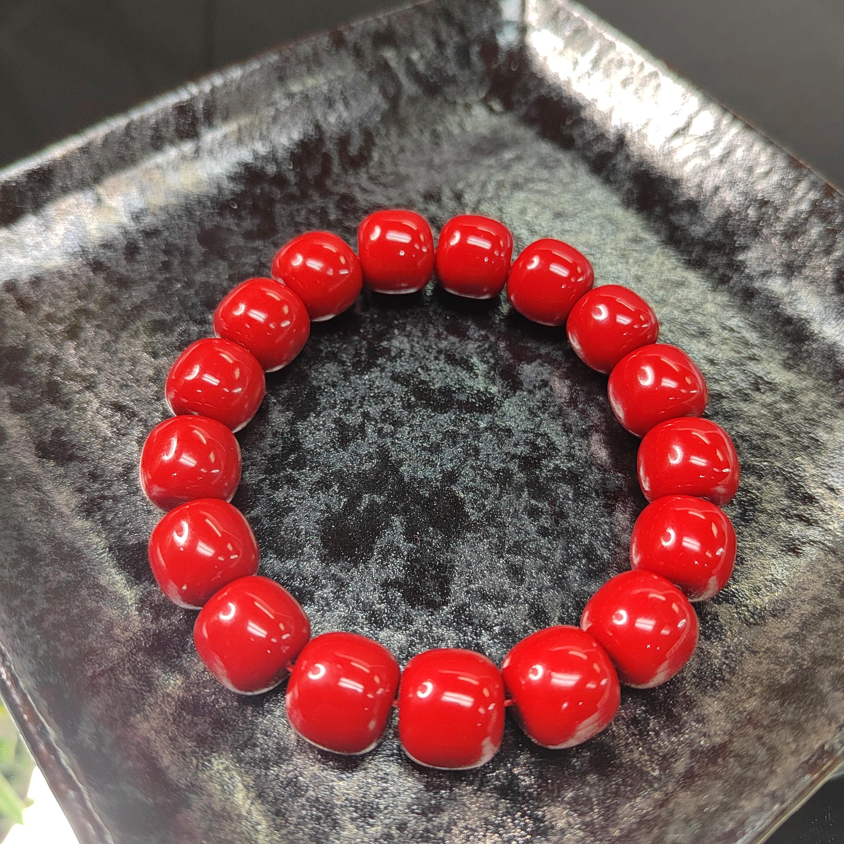 Red beaded bracelet on a textured black surface