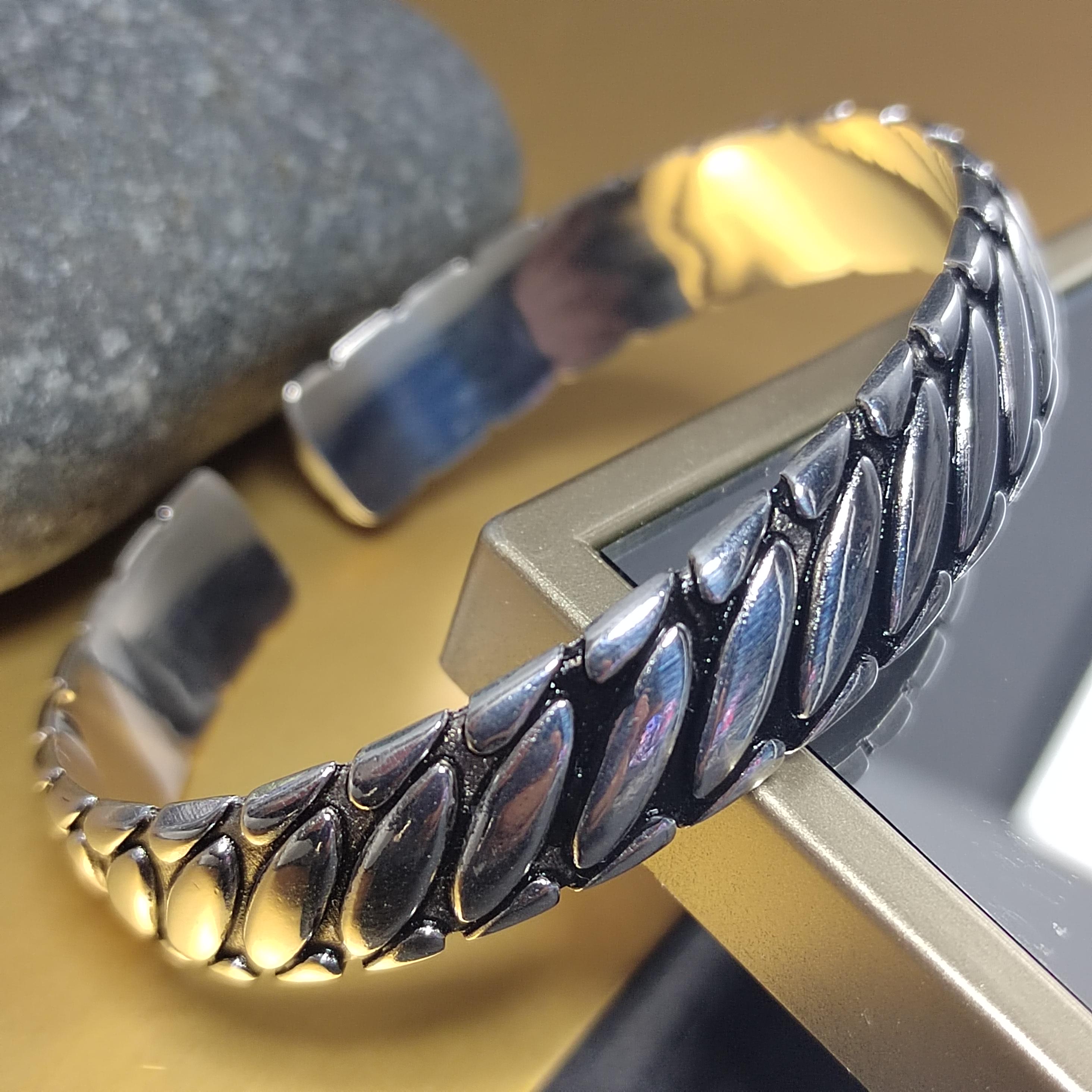 Silver bracelet with leaf-like design on a metallic stand