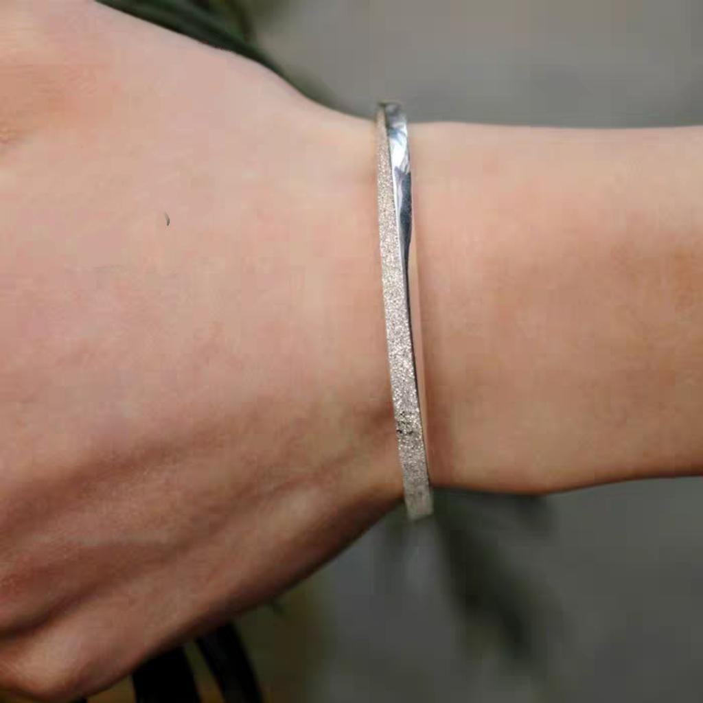 Silver bracelet on a wrist with a blurred background