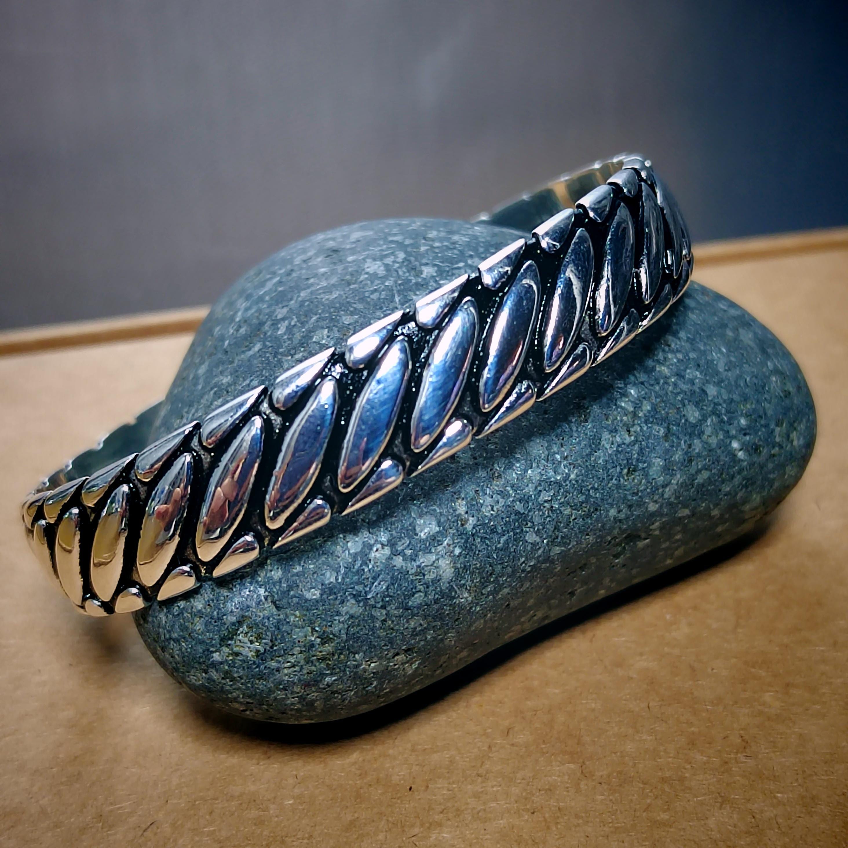 Silver bracelet on a textured stone surface with a neutral background