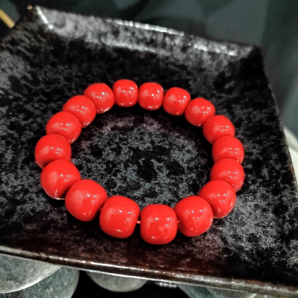 Red beaded bracelet on a textured black surface