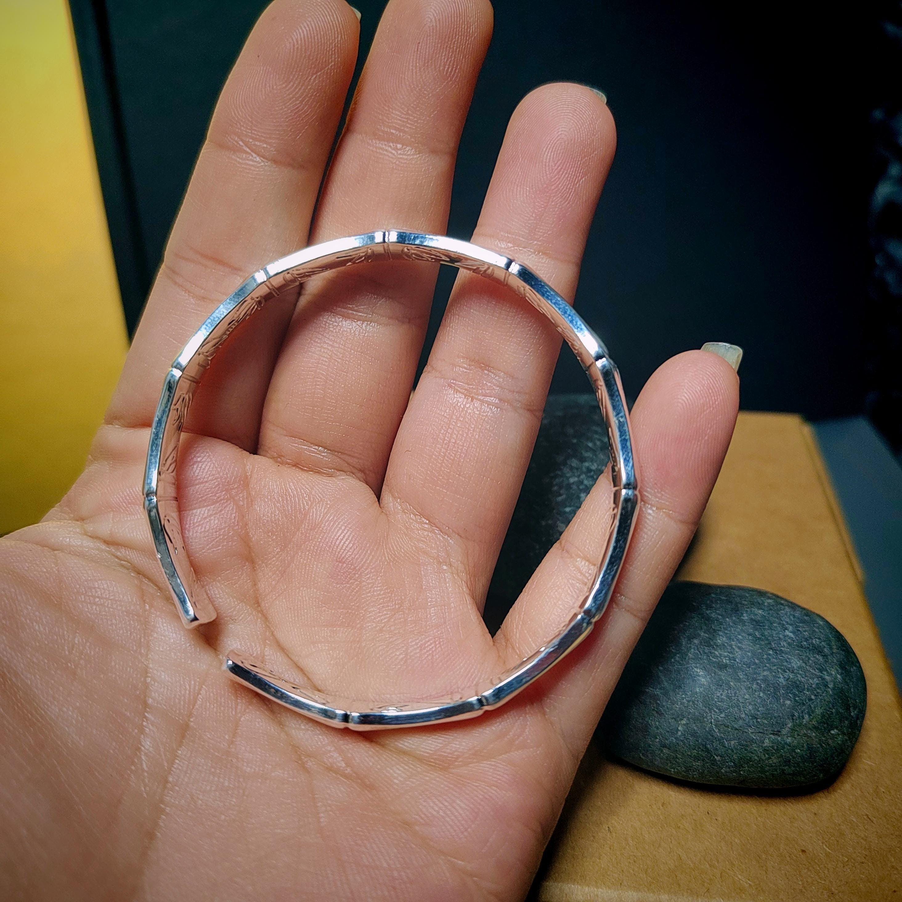Silver bangle on a hand with a blurred background