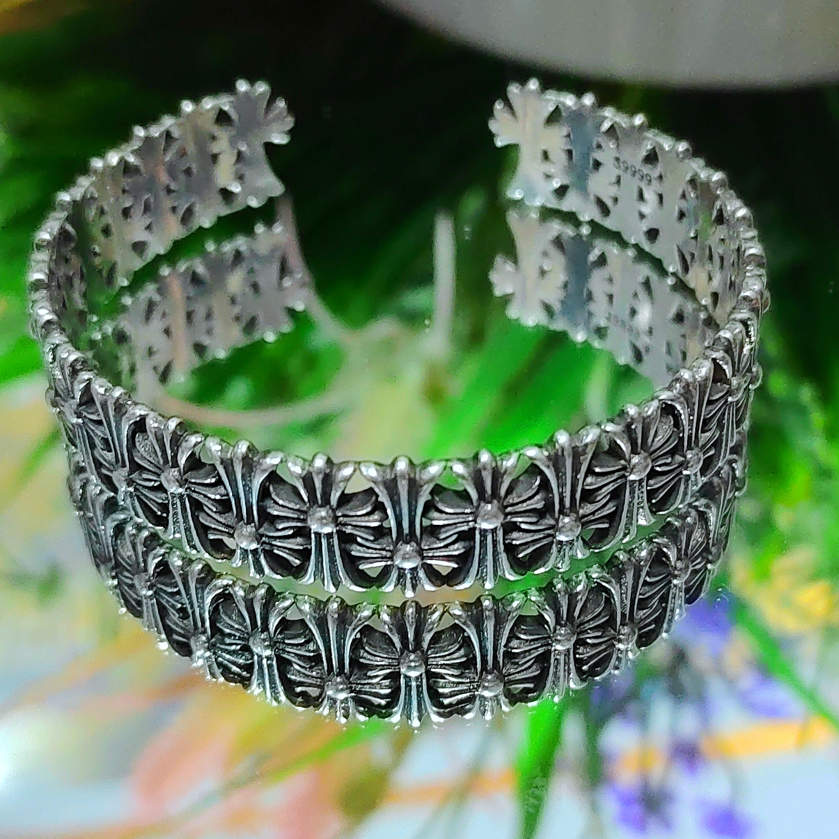 Silver bracelet with intricate design on a blurred natural background