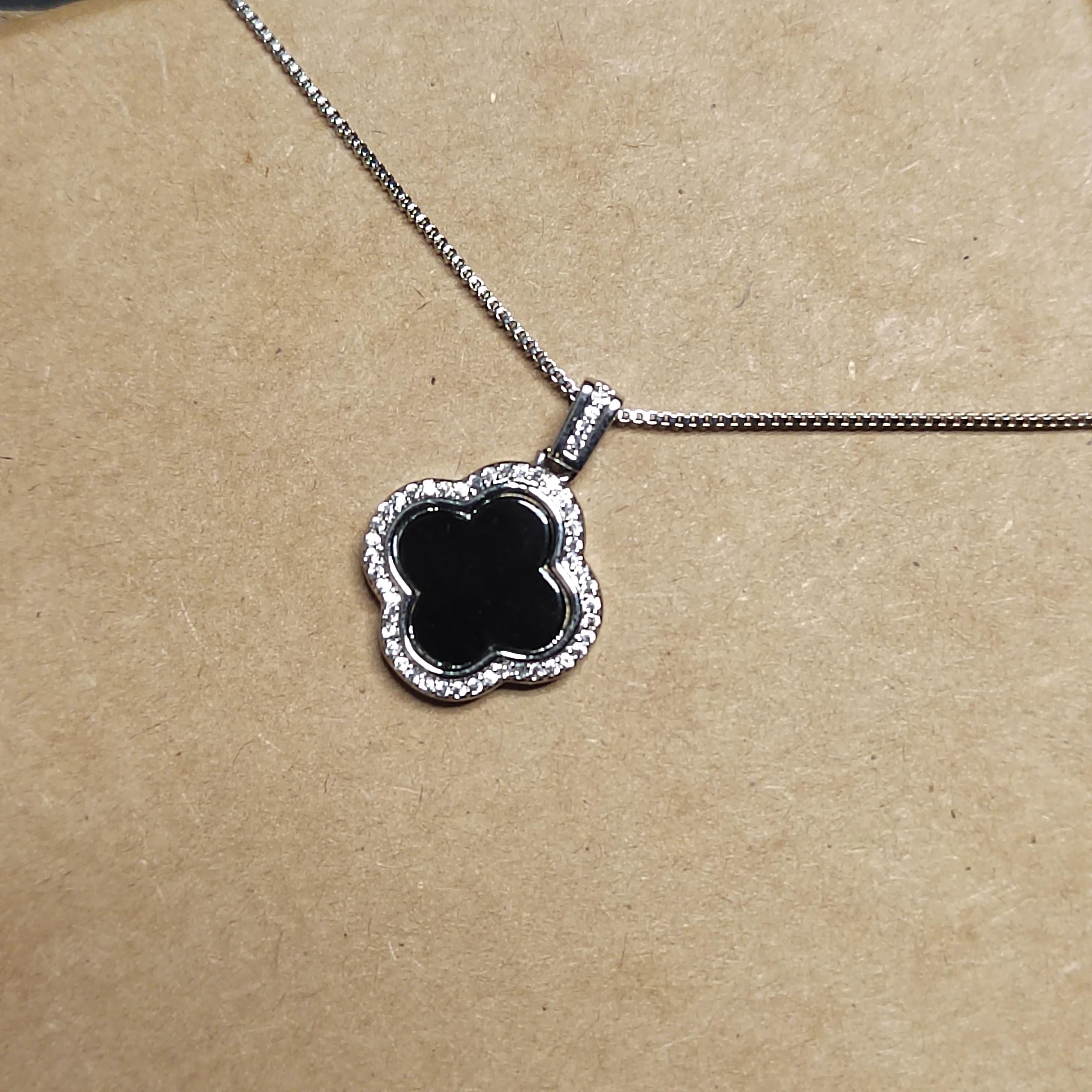 Necklace with a clover-shaped pendant on a brown background