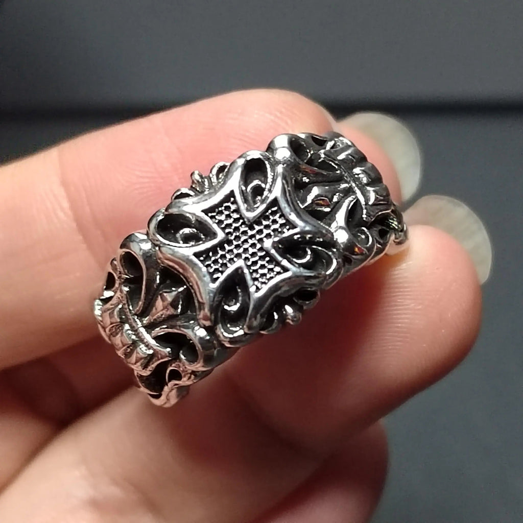 Silver ring with cross design.
