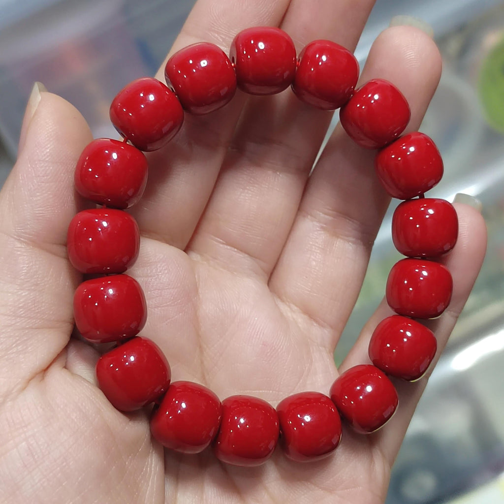 Red beaded bracelet on a hand with a blurred background