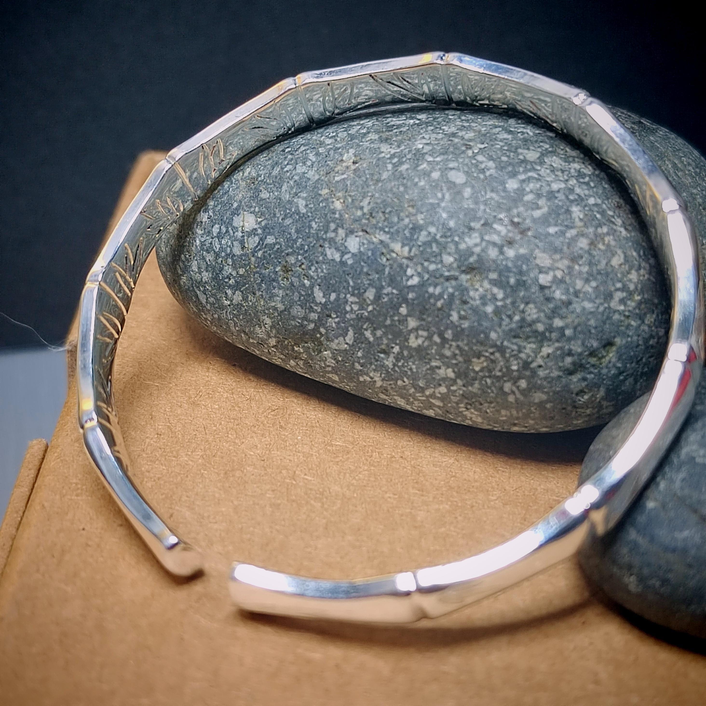 Silver bracelet with a stone on a textured surface