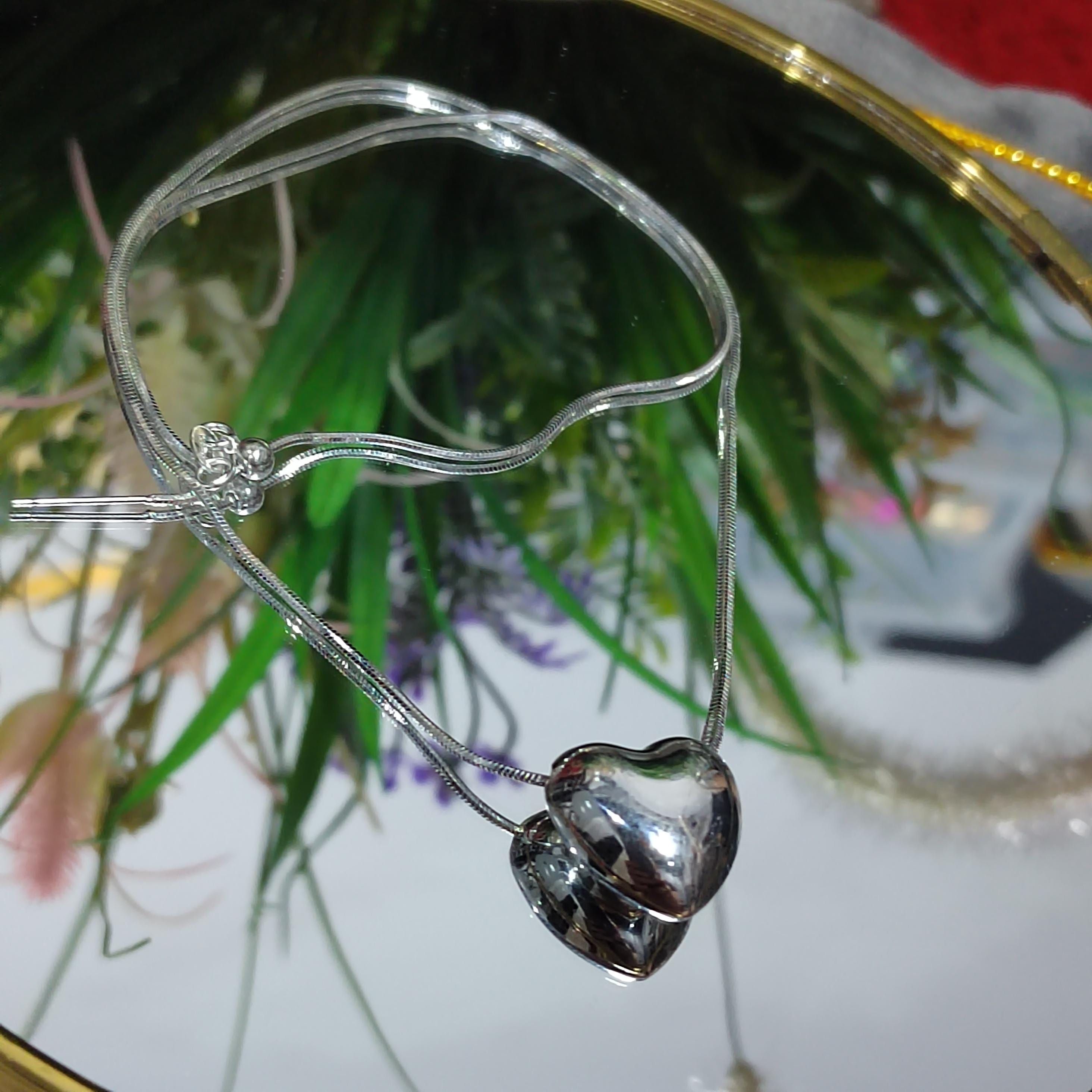 Silver heart-shaped pendant on a chain with a blurred background