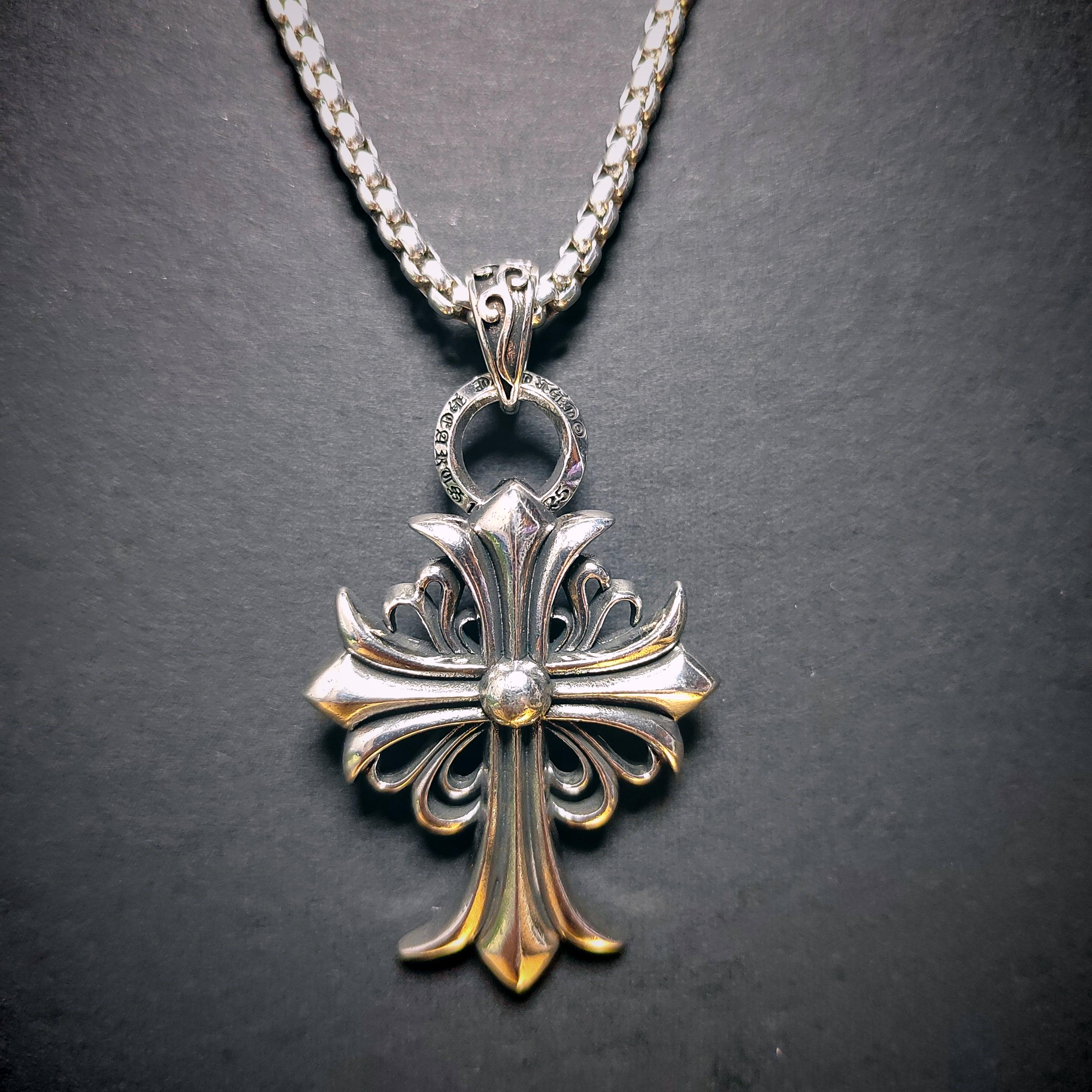 Silver cross pendant necklace on a dark background