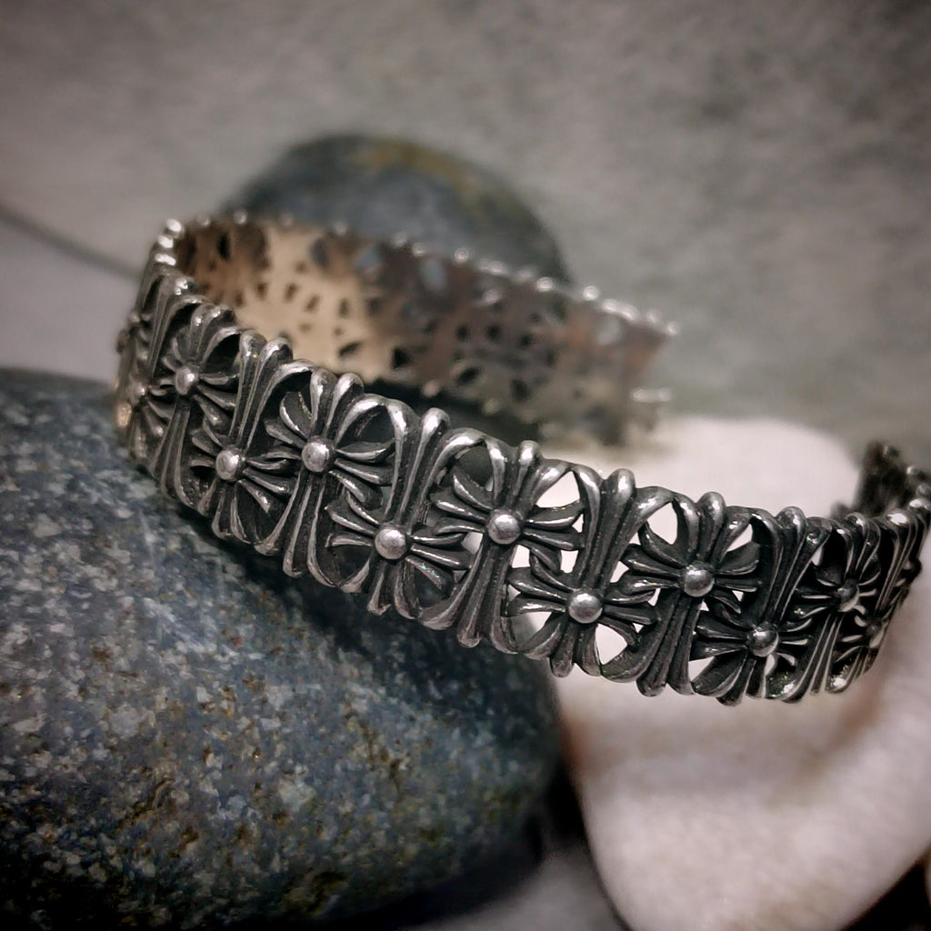 Silver bracelet with intricate design on a stone surface