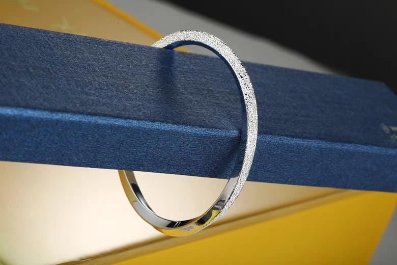 Silver ring on a blue and yellow striped background