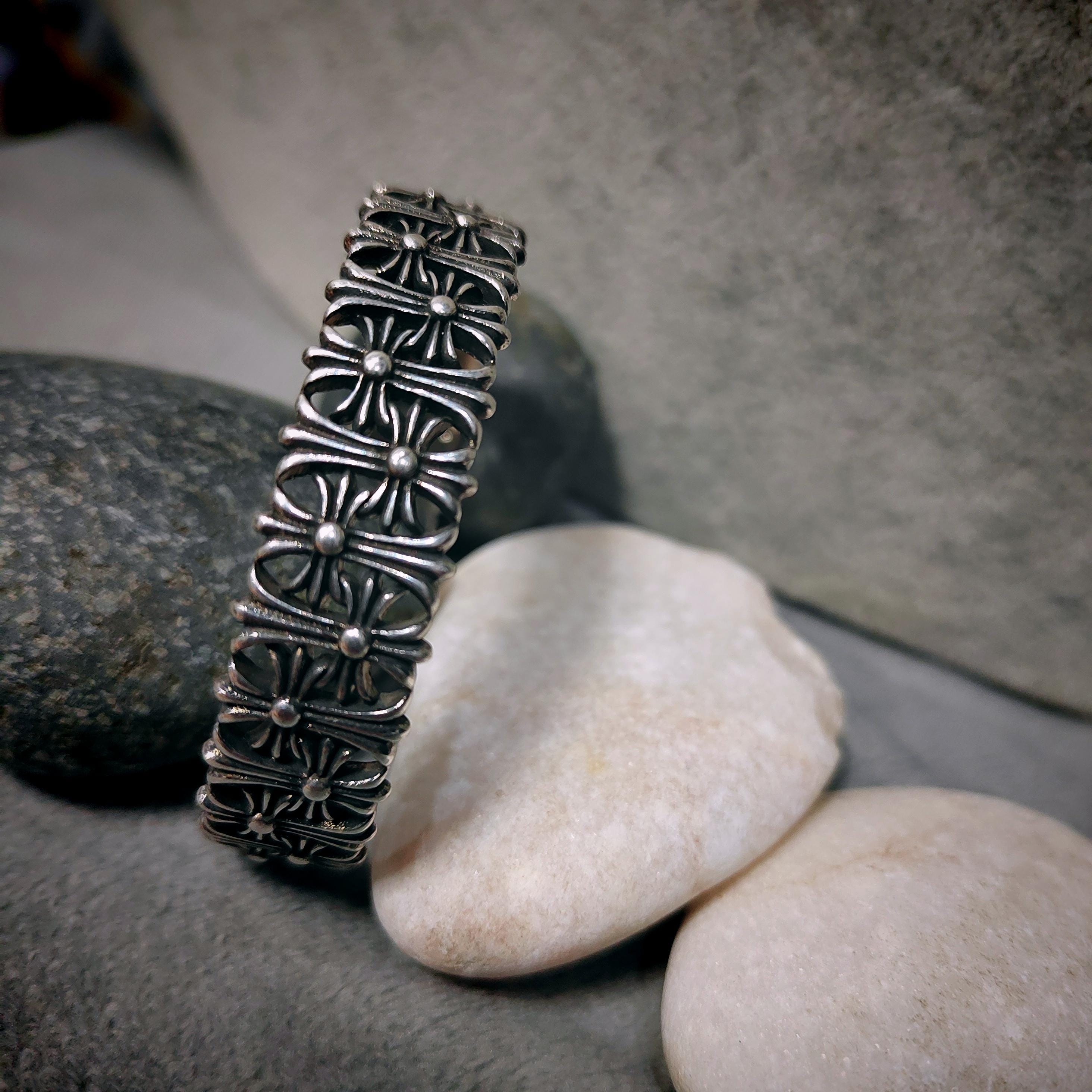 Silver bracelet with intricate design on a stone surface