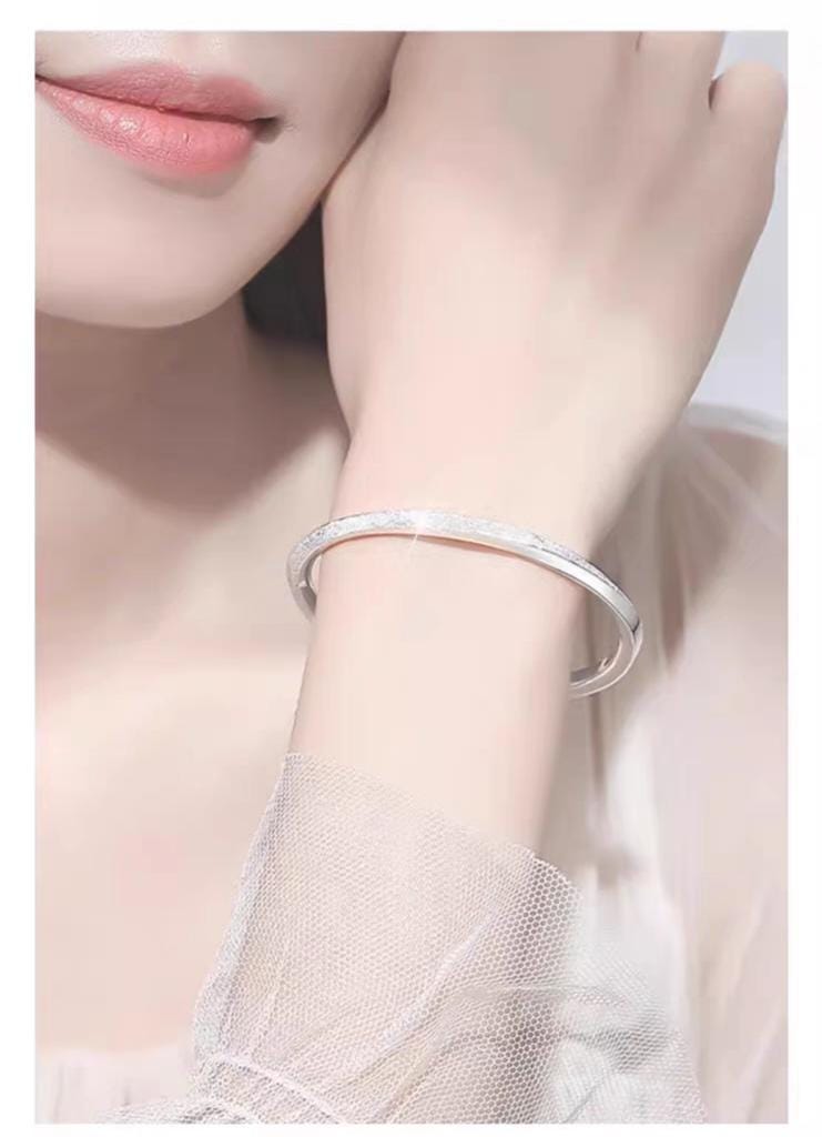Silver bracelet on a wrist with a soft background