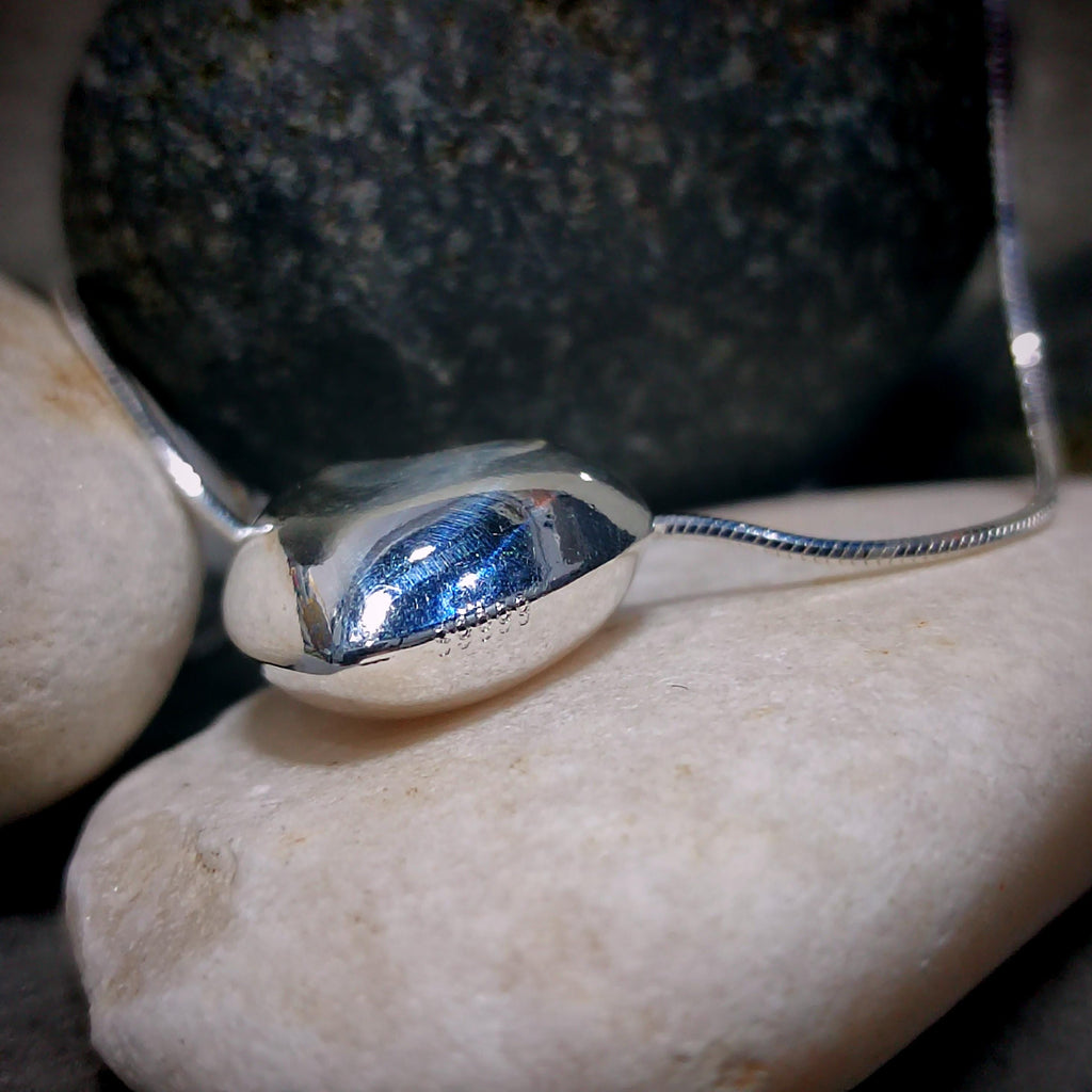 Silver bracelet with a blue stone on a rock