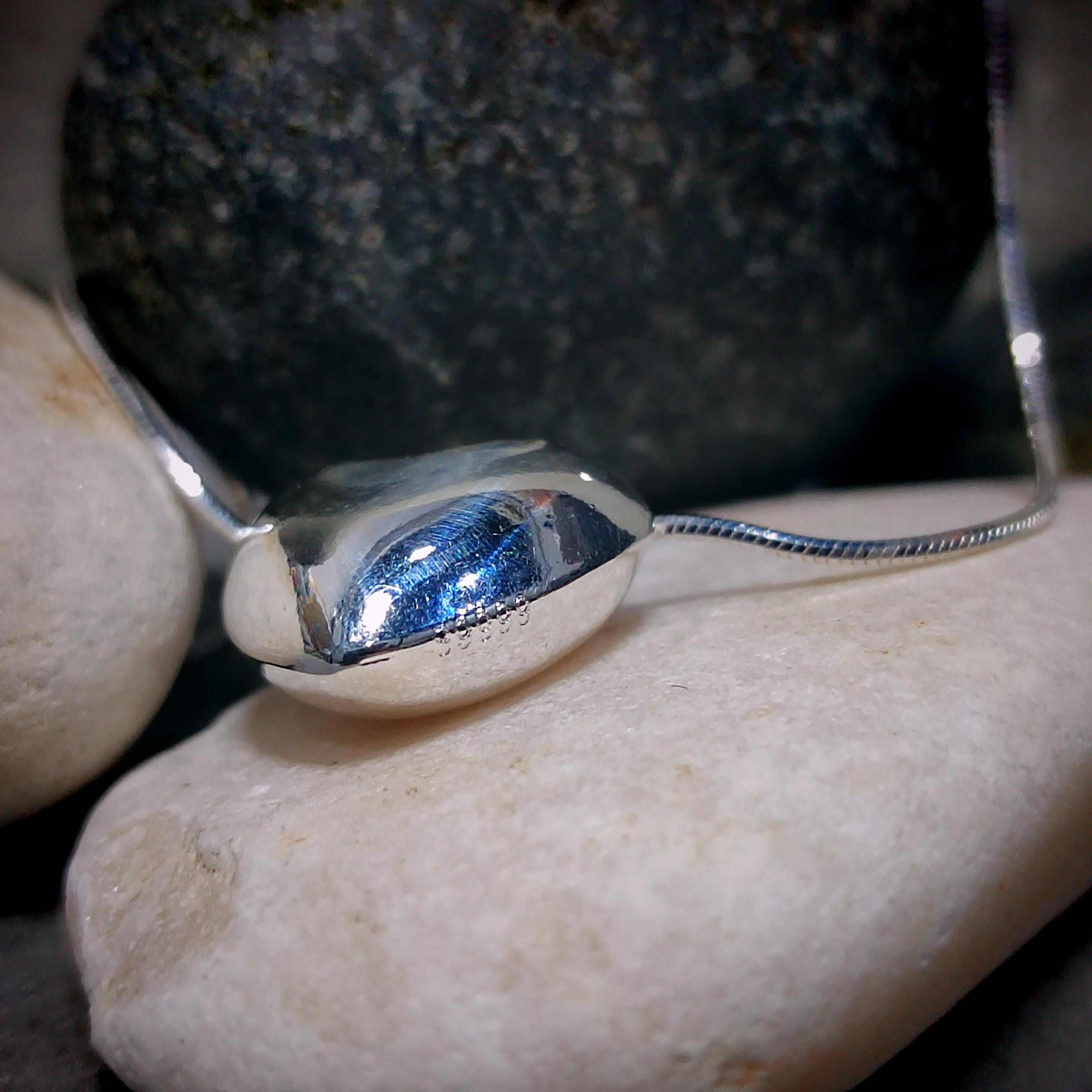 Silver bracelet with a blue stone on a rock