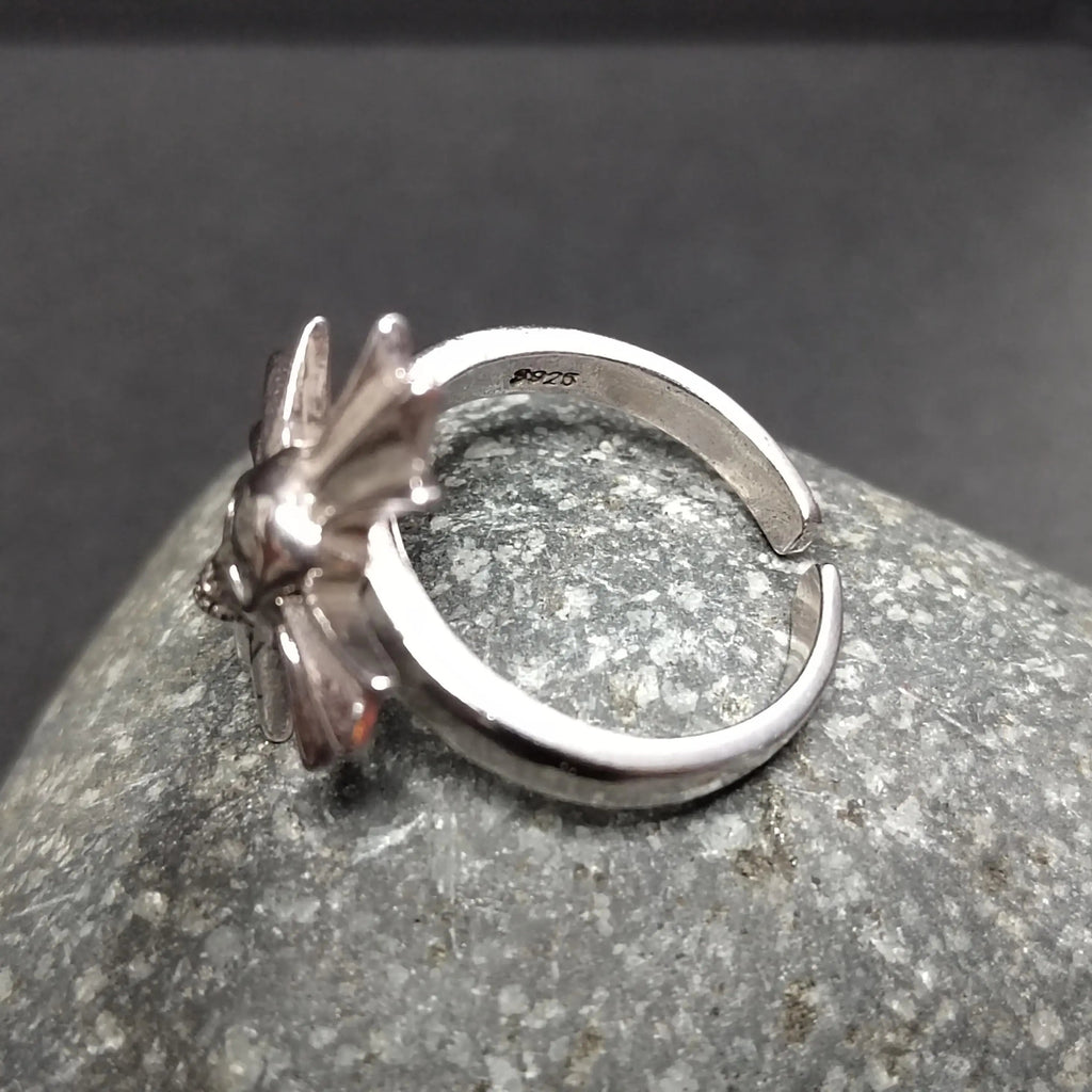 Silver ring with a unique design on a gray stone surface