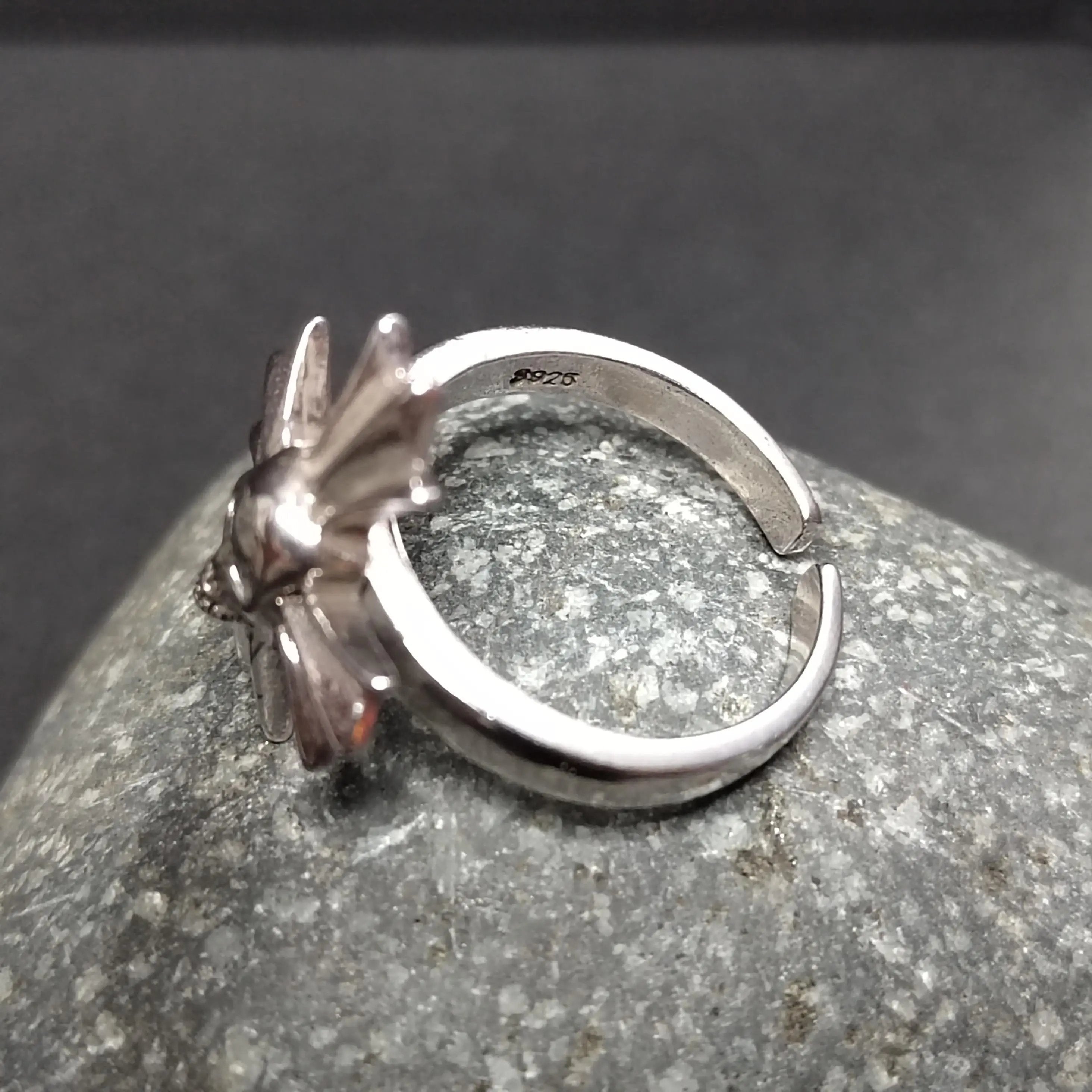 Silver ring with a unique design on a gray stone surface