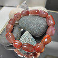 Handcrafted bracelet with uneven red Nanhong agate cylinder beads featuring natural black iron skin inclusions.