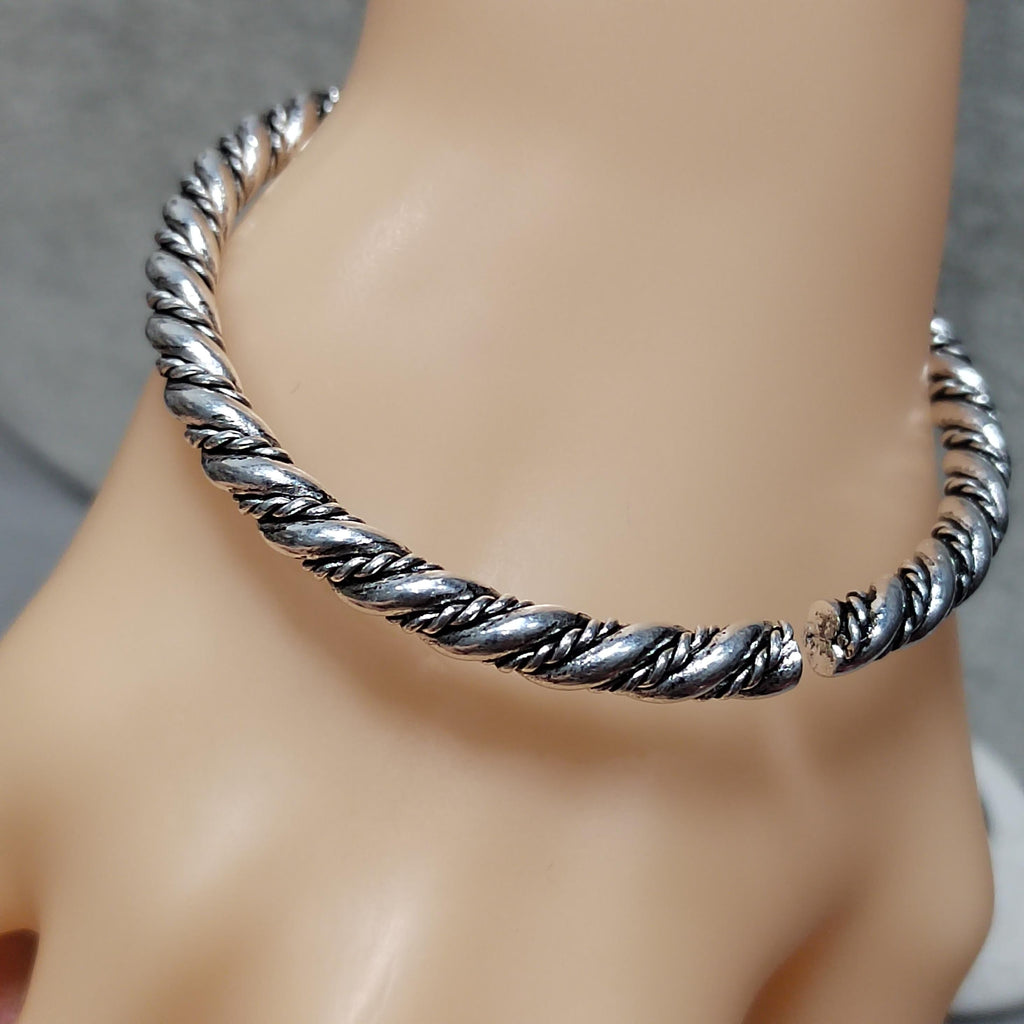Silver braided anklet on a mannequin foot against a neutral background
