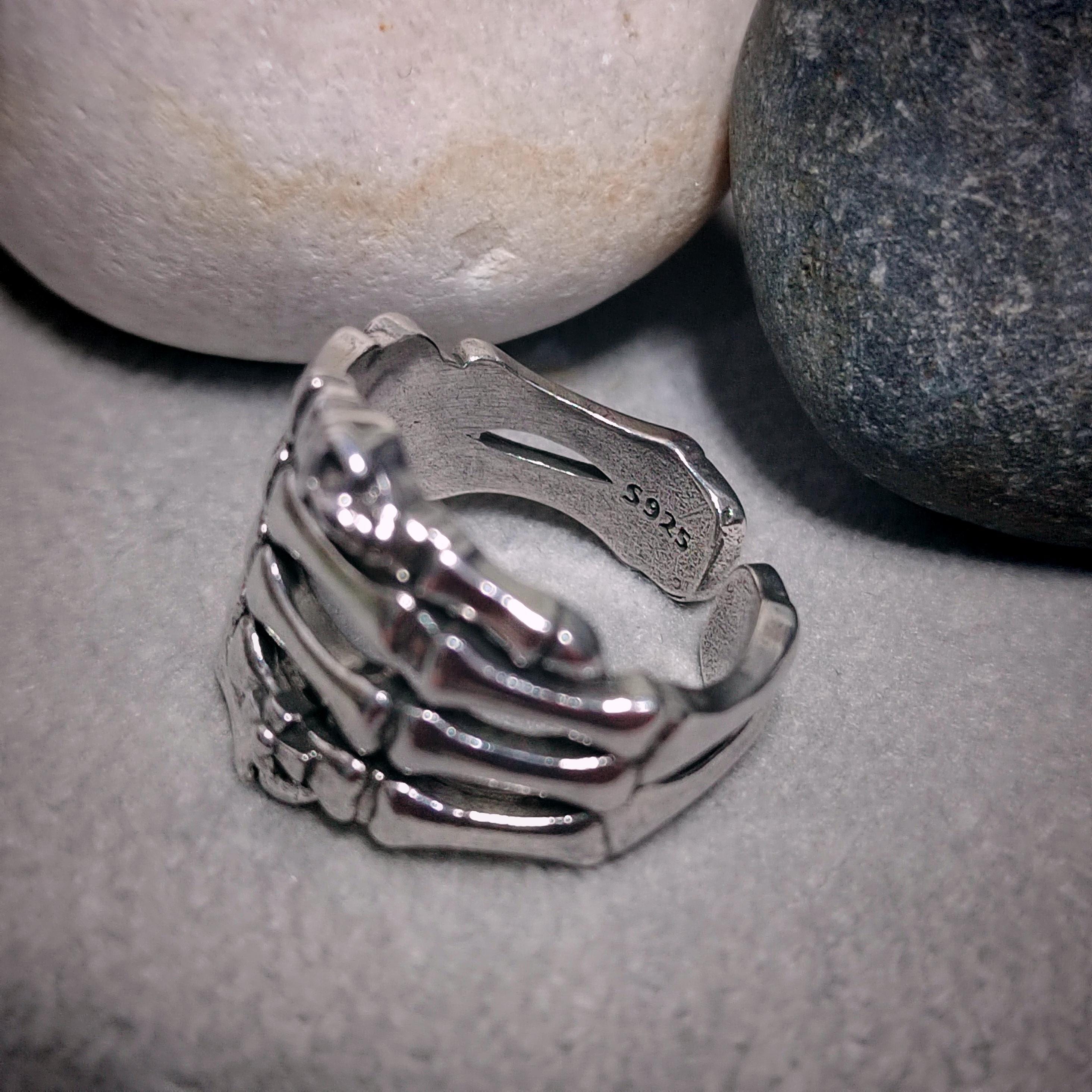 Silver ring with a unique design on a textured surface