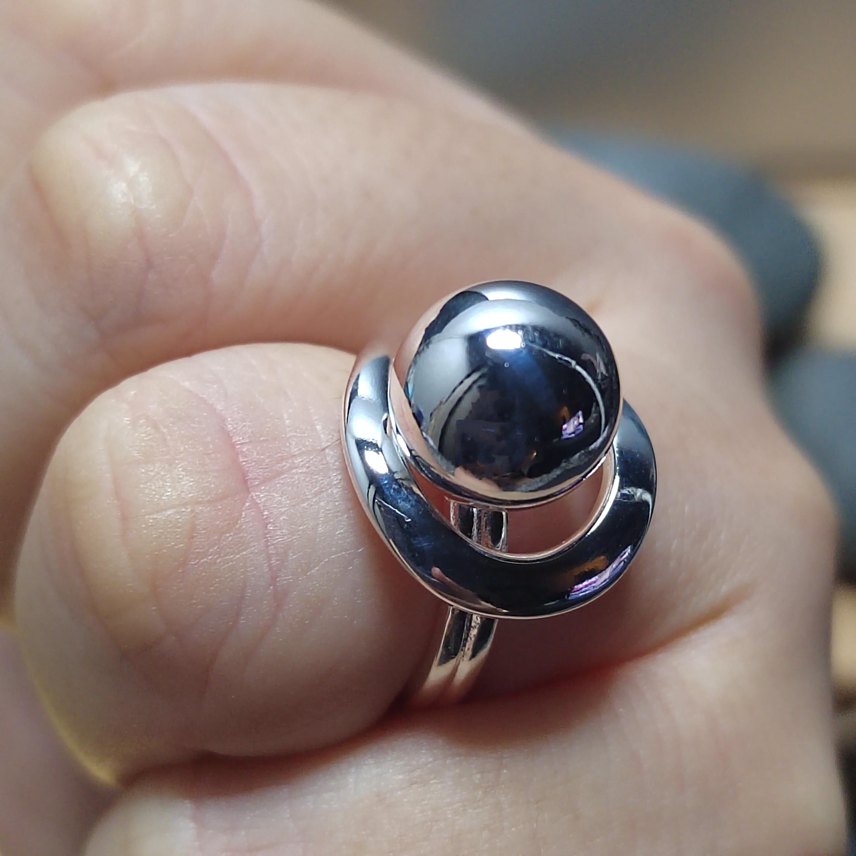 Silver ring with a large black gemstone on a person's finger