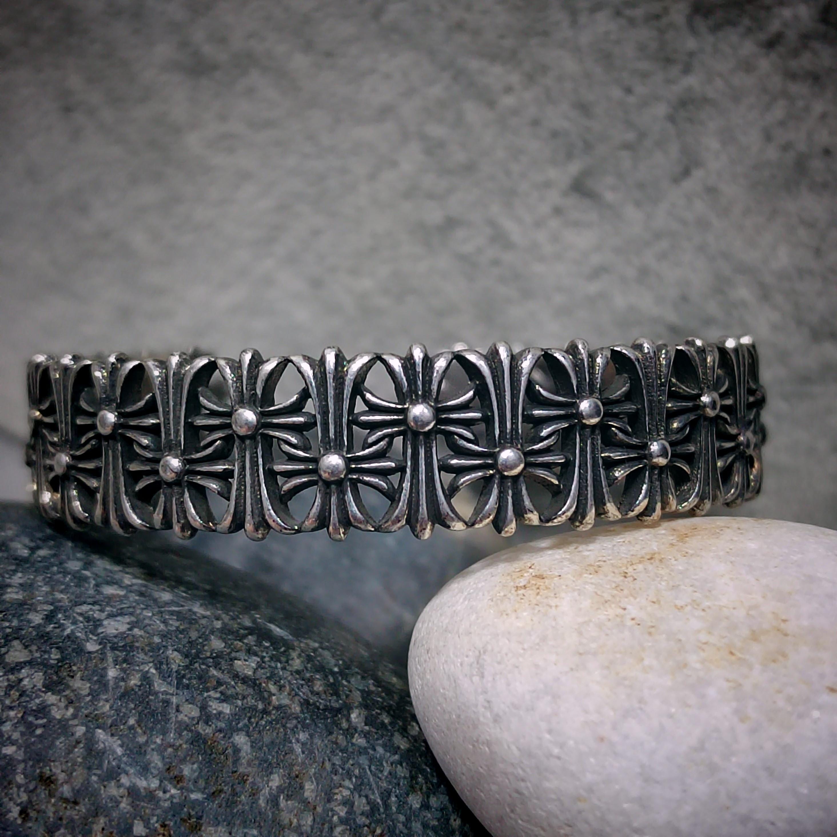 Silver bracelet with intricate design on a stone surface