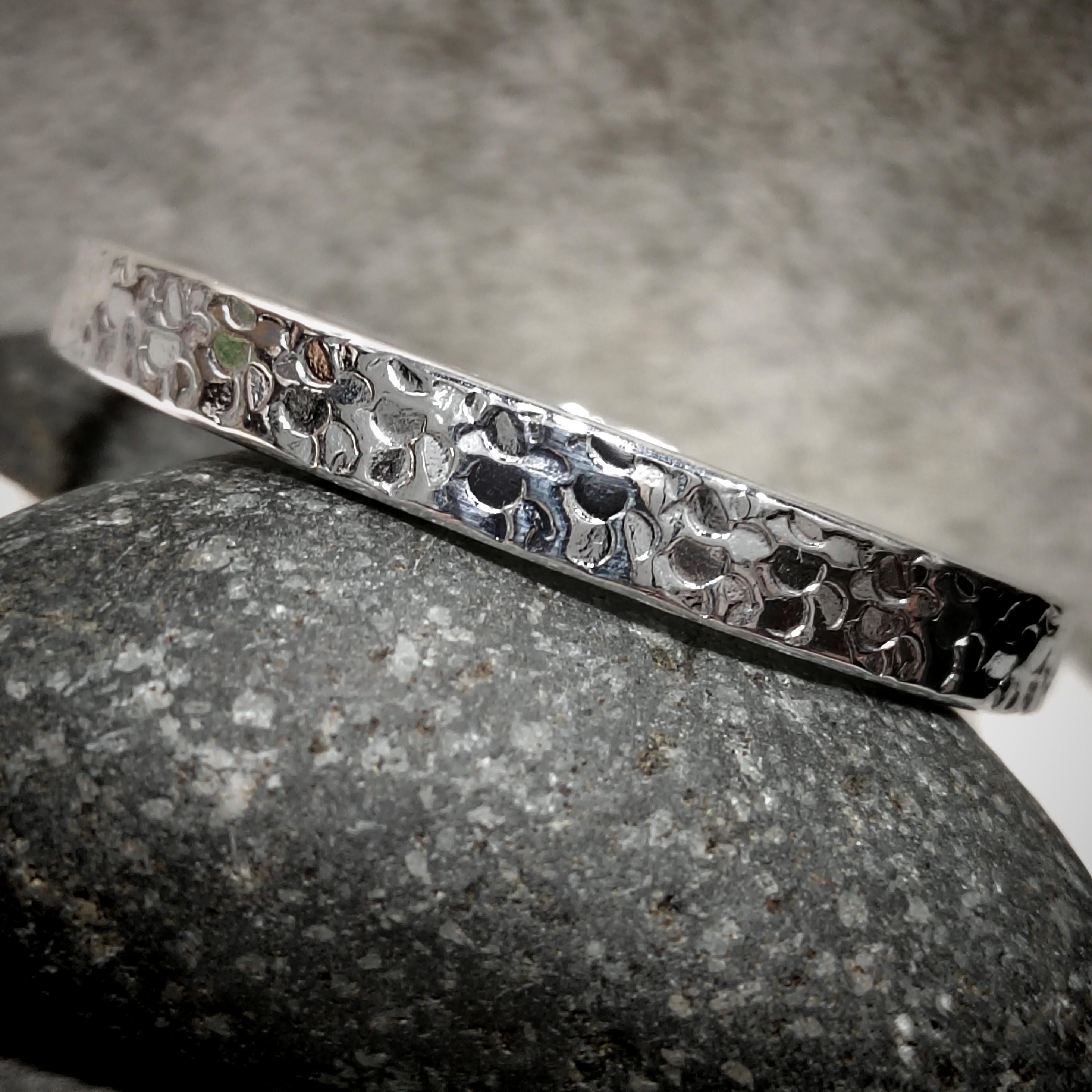 Silver bracelet with a textured pattern on a gray stone surface