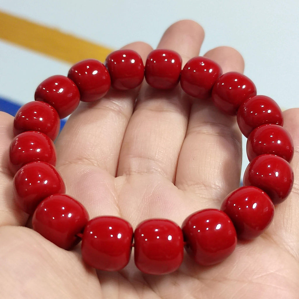 Red beaded bracelet on a hand with a blurred background