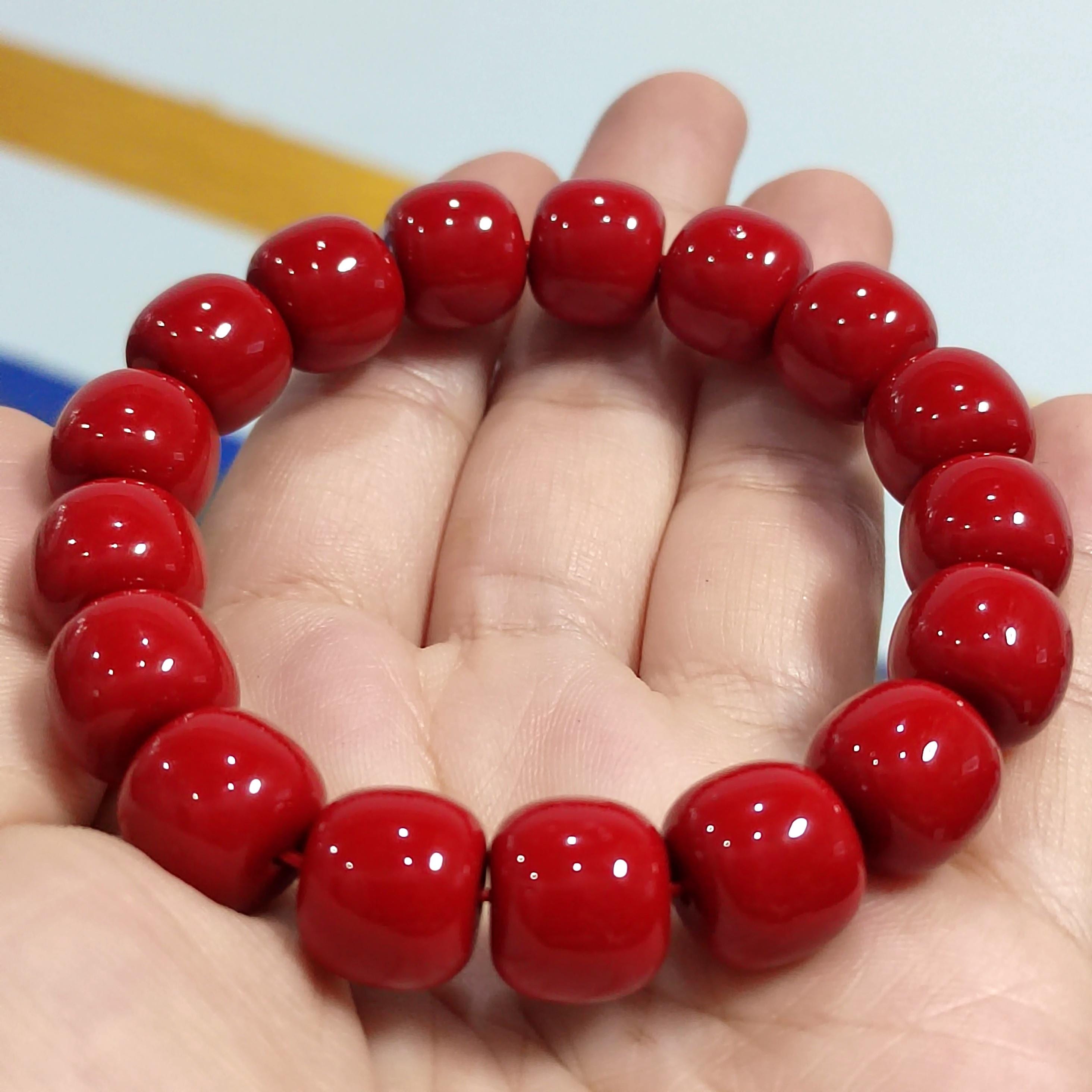 Red beaded bracelet on a hand with a blurred background