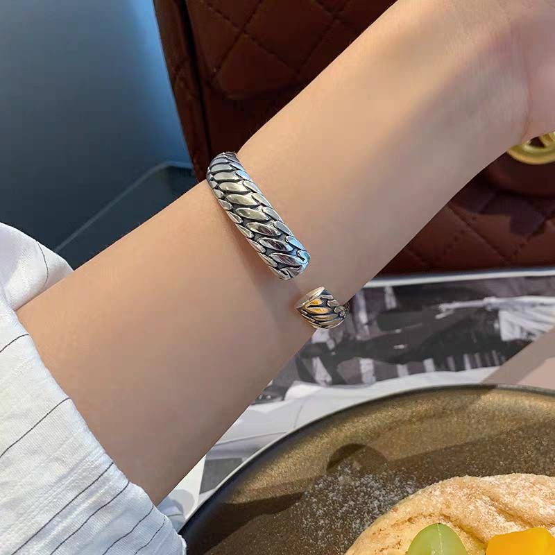 Silver bracelet on a wrist with a blurred background