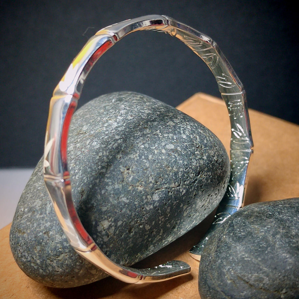 Clear glass ring with engraved design on a dark background