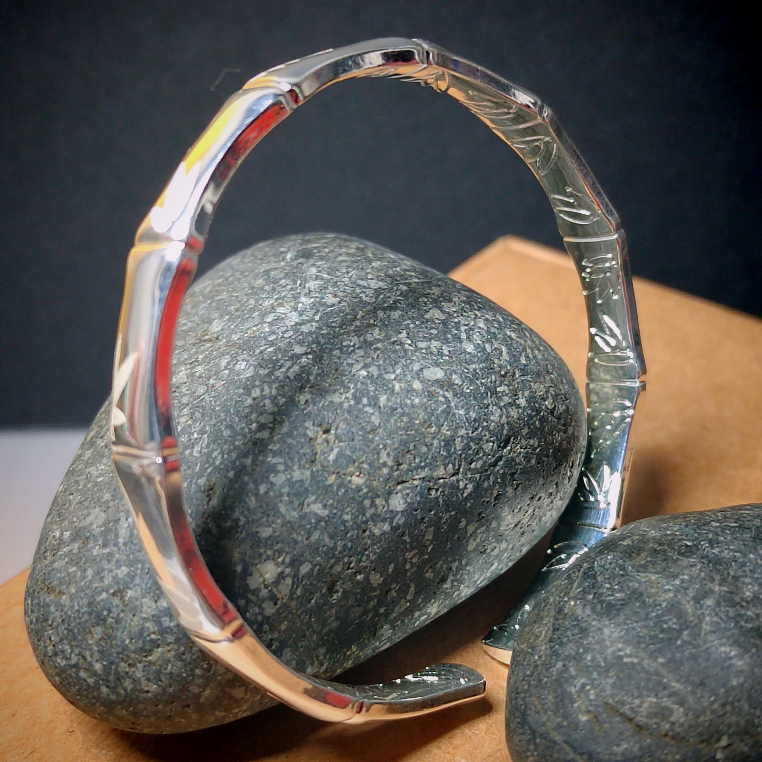 Clear glass ring with engraved design on a dark background