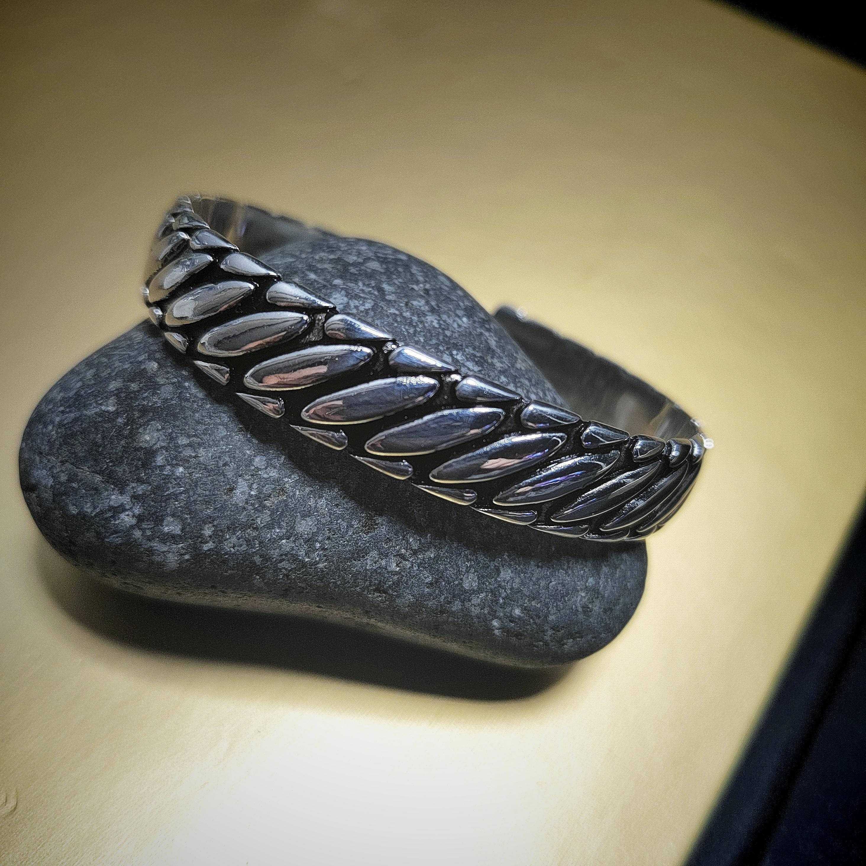 Silver bracelet on a dark stone surface with a neutral background