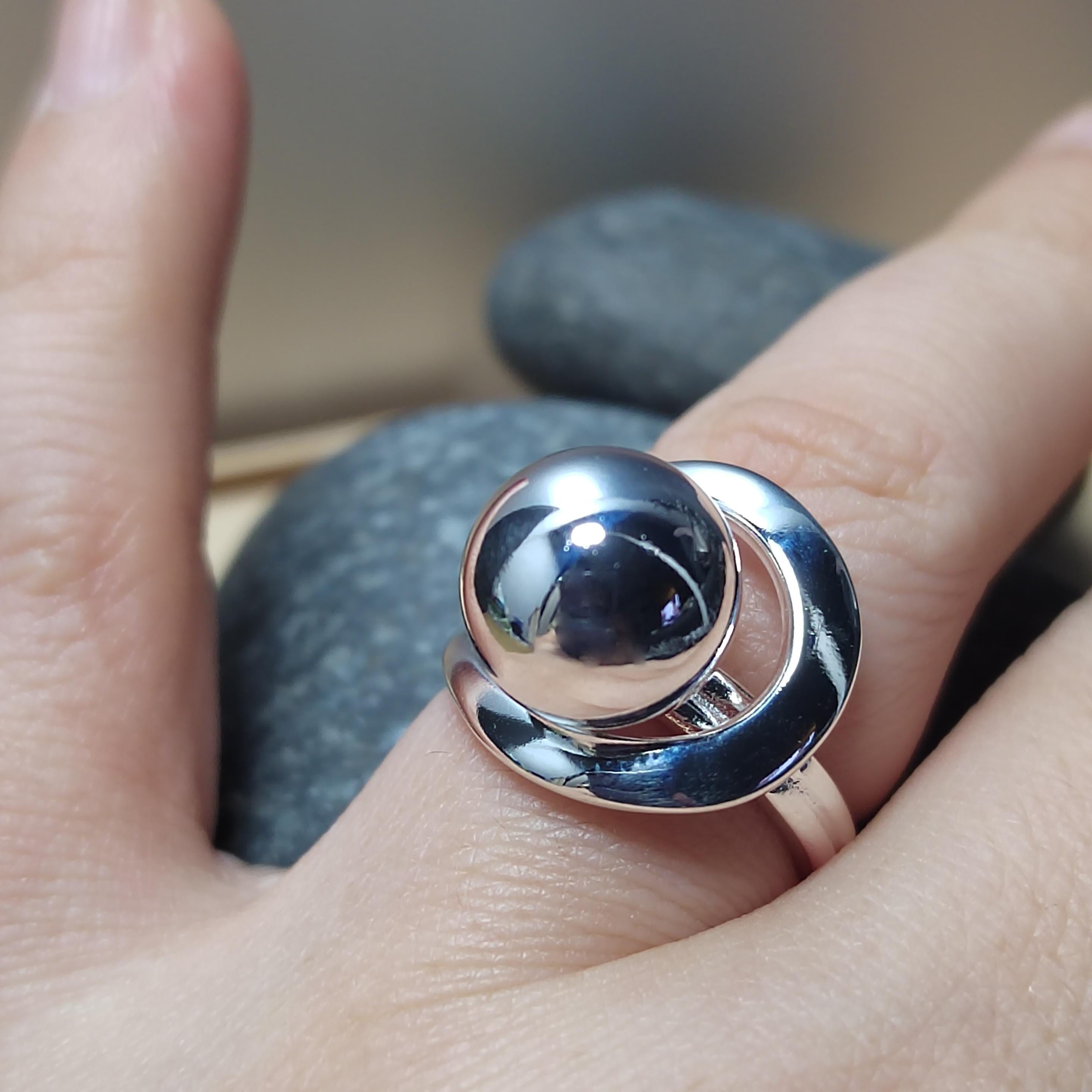 Silver ring on a person's finger with a blurred natural background