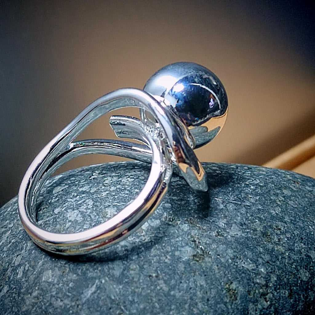 Silver ring with a blue gemstone on a stone surface