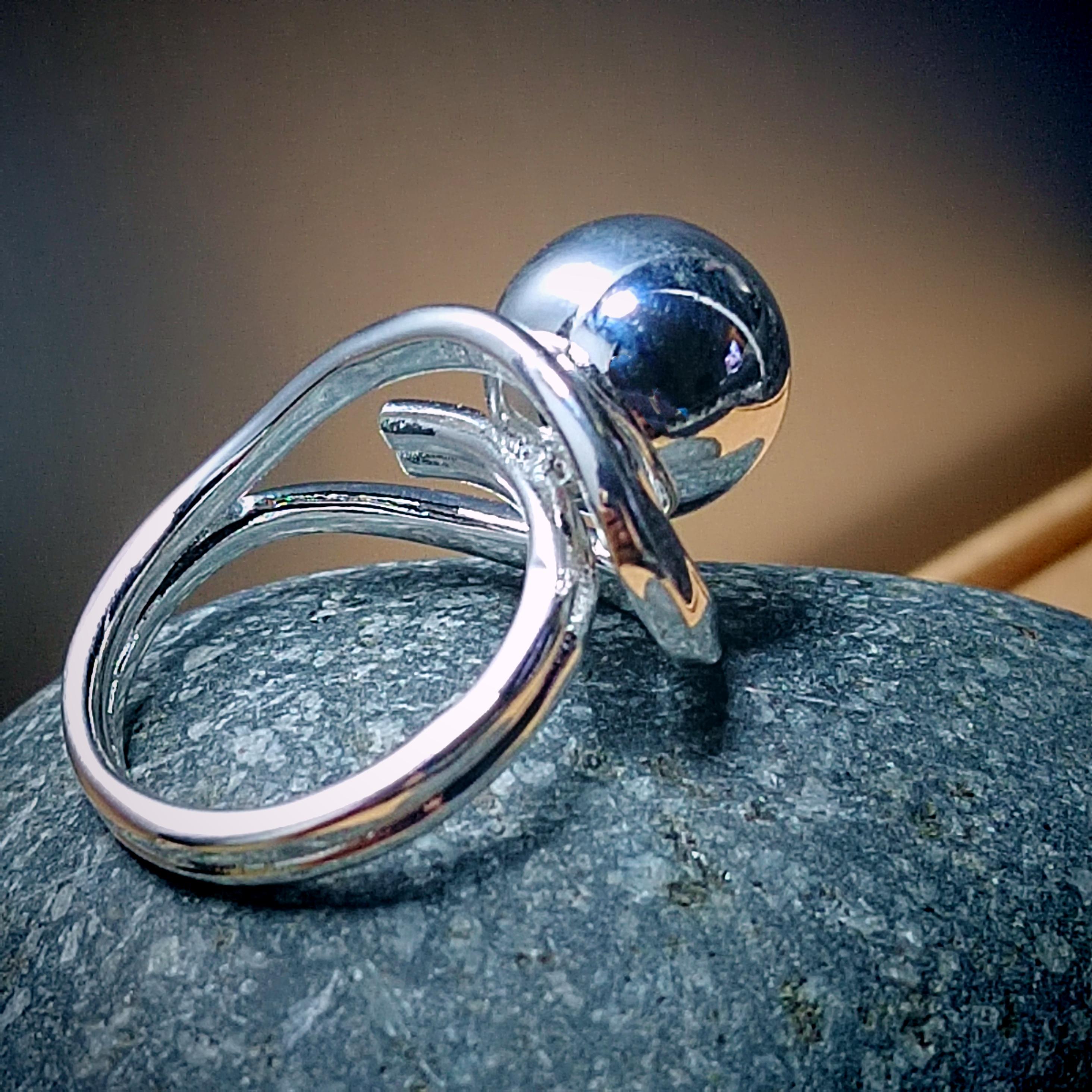 Silver ring with a blue gemstone on a stone surface