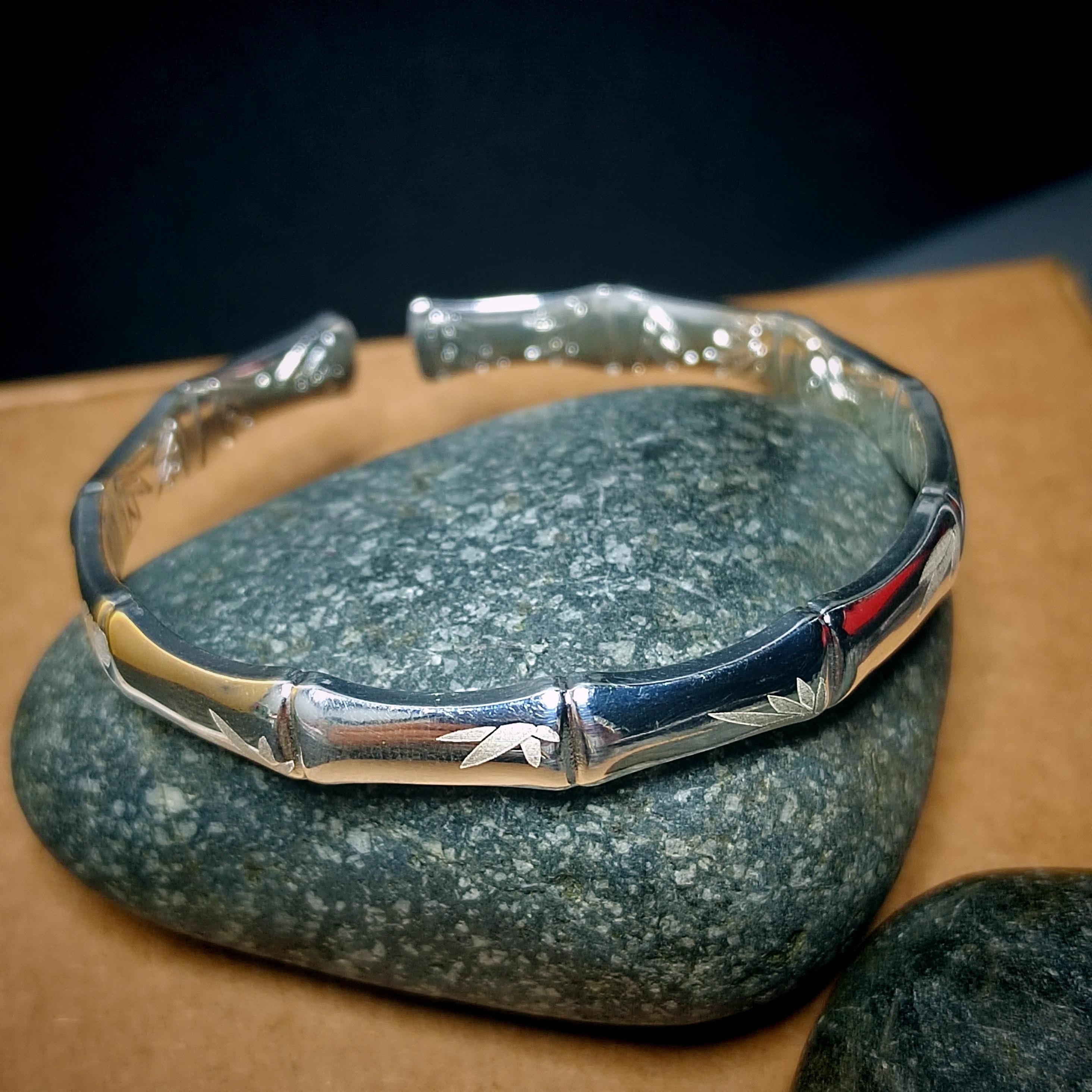Silver bracelet with engraved design on a stone surface