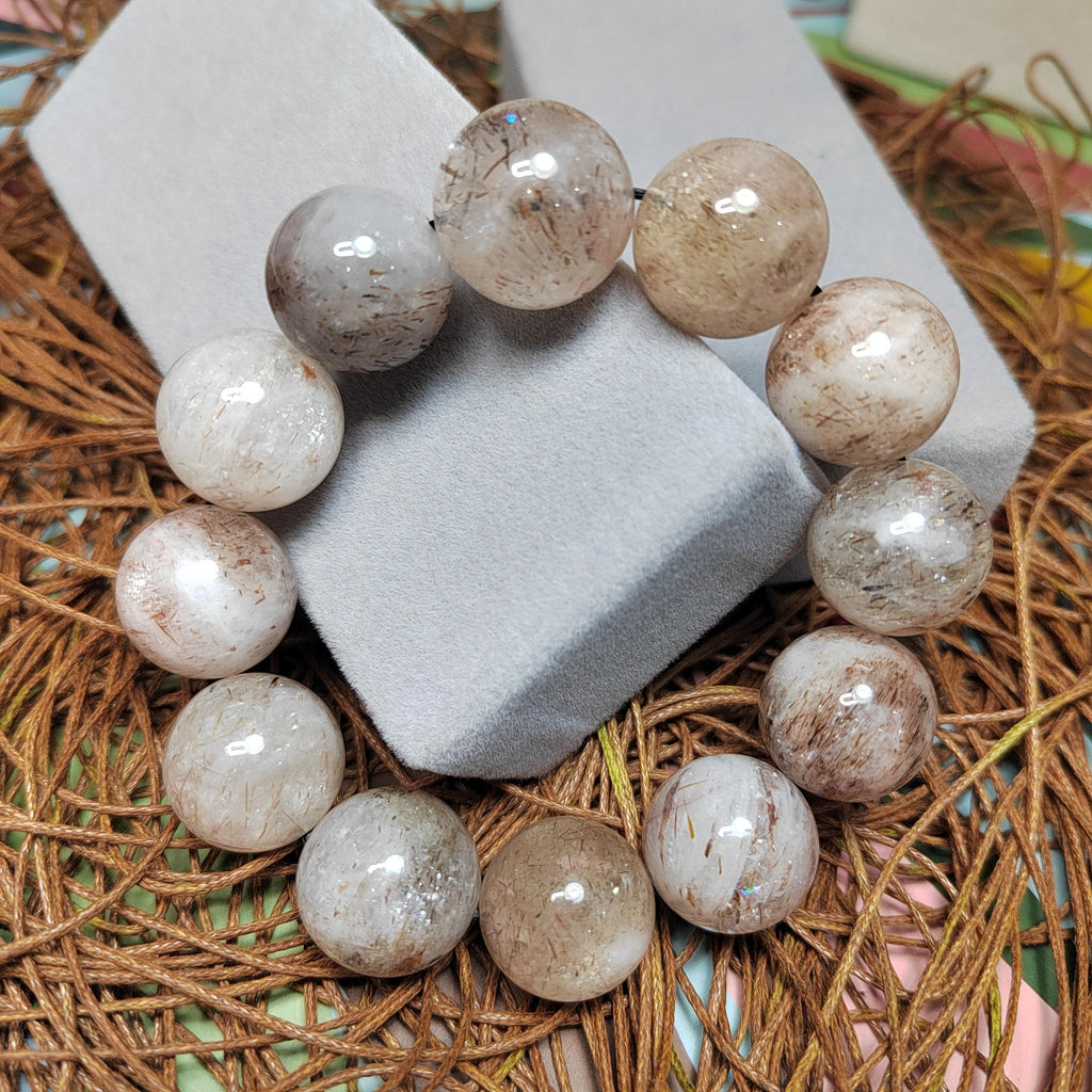 Beige stone bead bracelet on a textured surface