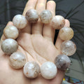 Hand holding a stack of round, beige-colored stones.