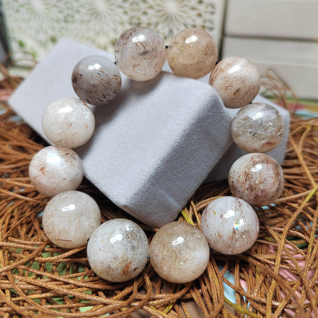Beige stone bead bracelet on a white block with a natural background