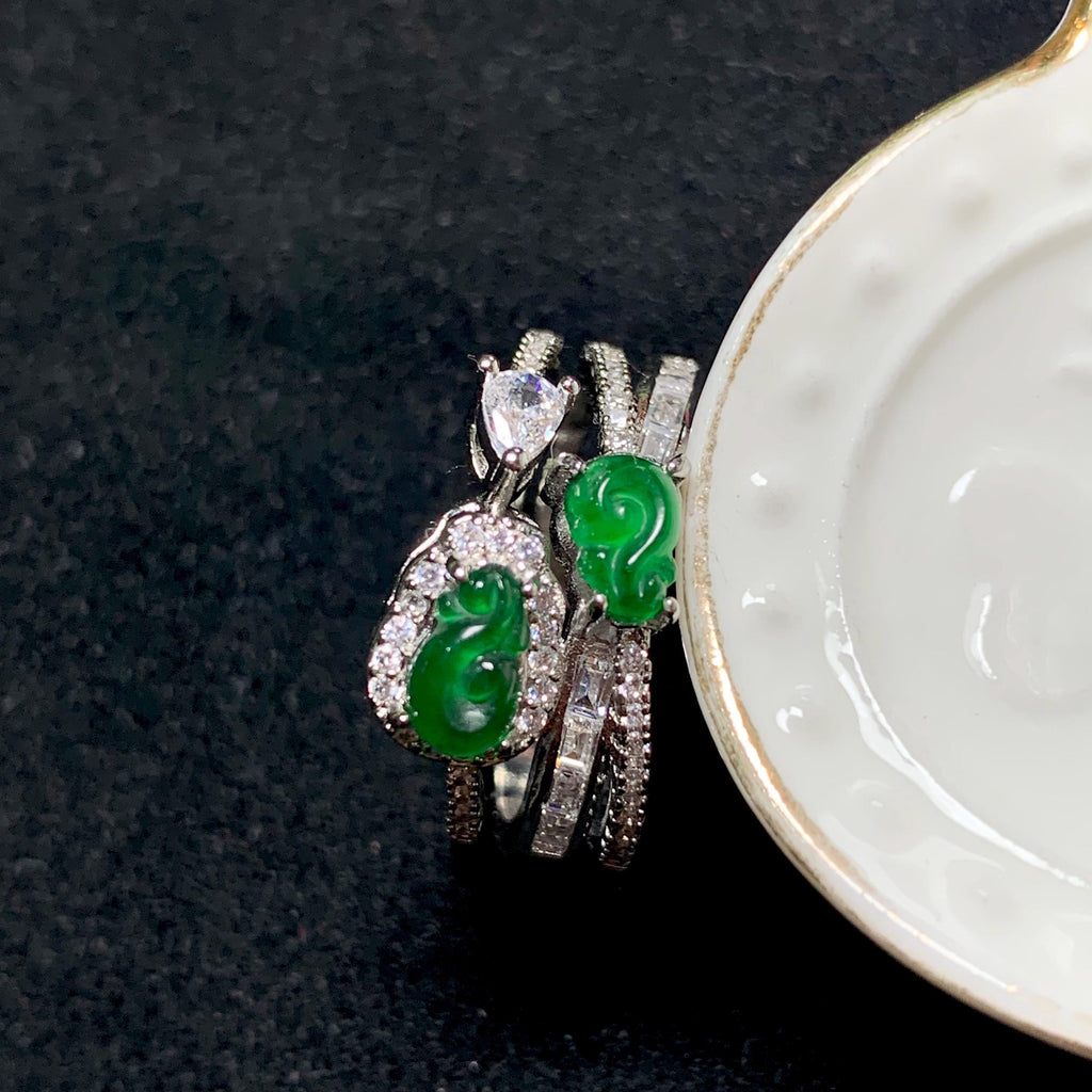 Jewelry set with green gemstones and silver accents on a dark background