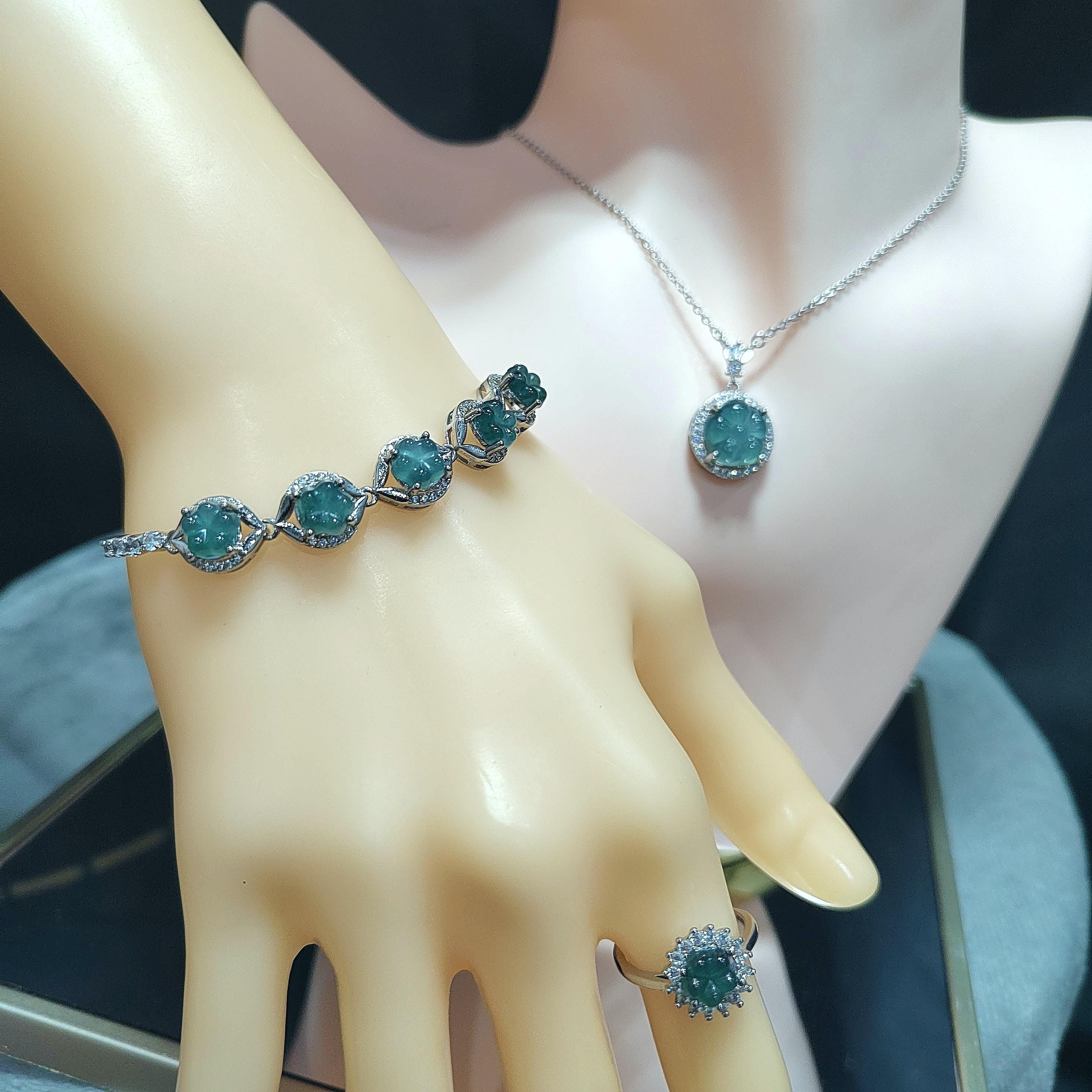 Jewelry set with bracelet, necklace, and ring featuring blue gemstones on a mannequin hand.