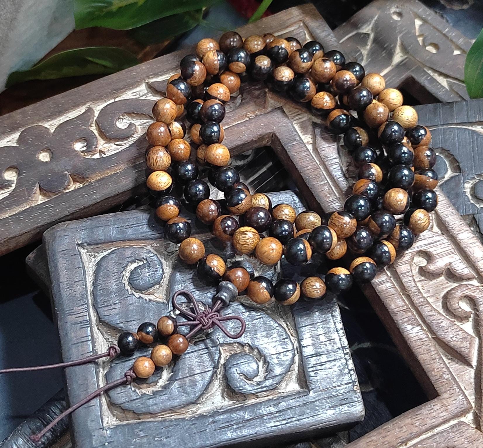 Beaded necklace with black and brown beads on a decorative wooden surface