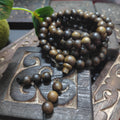 Wooden beads on a decorative wooden block with a leaf in the background