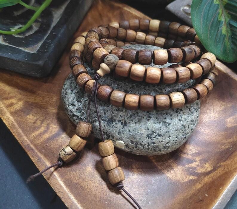Wooden beaded necklace on a stone surface with a natural background
