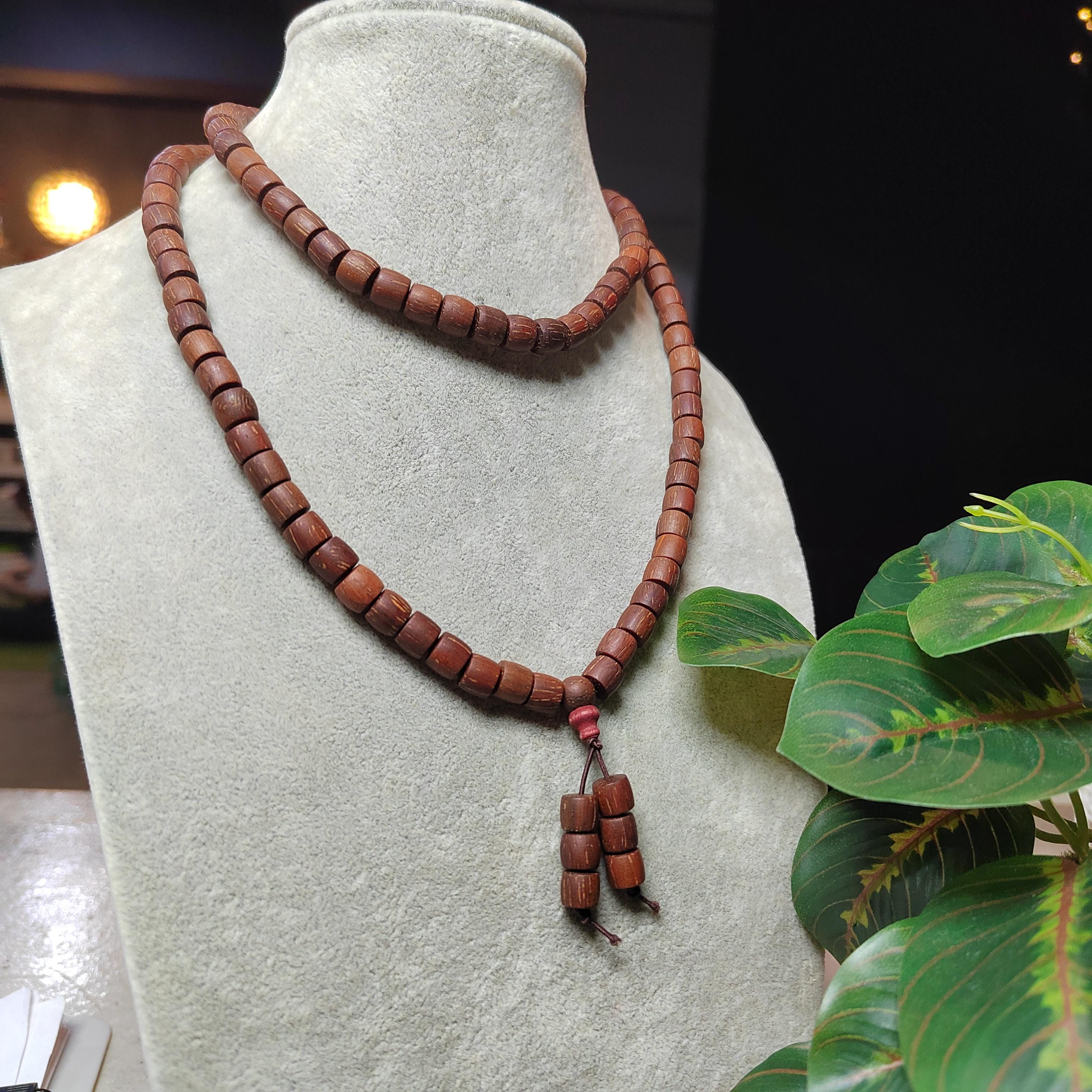 Wooden beaded necklace on a mannequin bust with a dark background