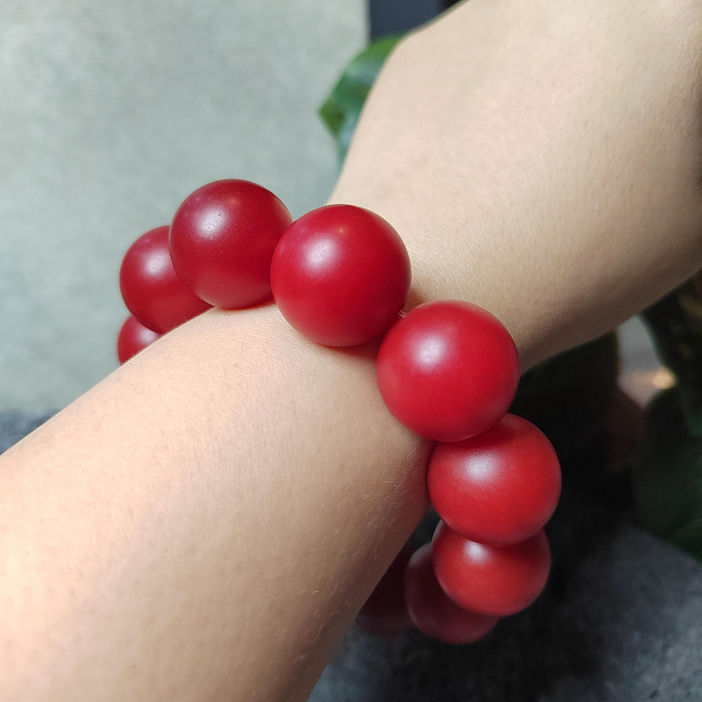 Red beaded bracelet on a wrist with a blurred background