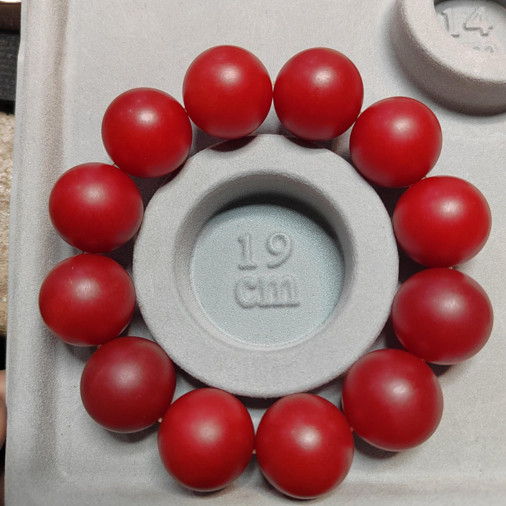 Red spherical objects surrounding a gray circular object with measurement markings.