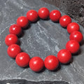 Red beaded bracelet on a gray stone surface